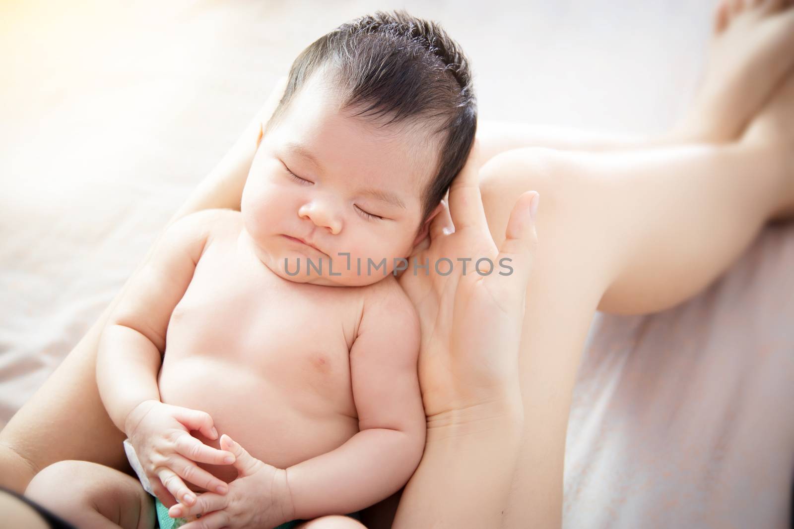 Concept of love and family relationship : close up newborn cute little Asian baby eye close feel comfortable to sleeping on hand of young mother at home, Top view. Asia baby portrait. by asiandelight