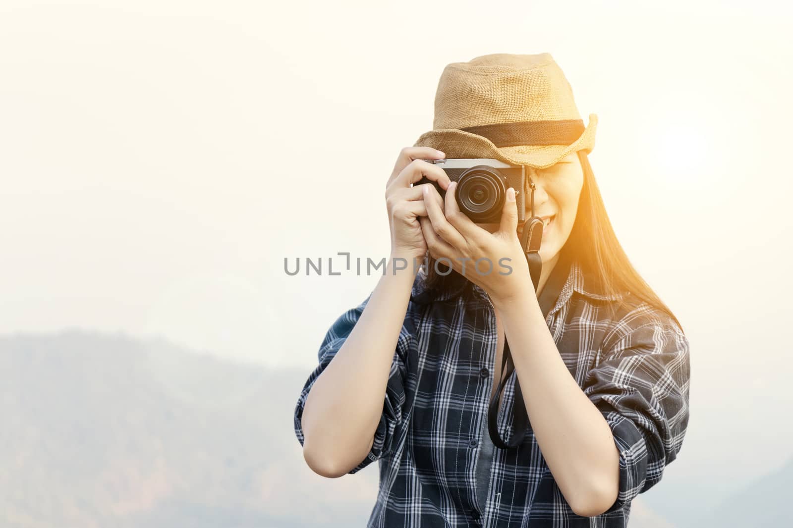 Travel Lifestyle vacations concept : Happy female traveler with camera making photo for good memory in tourist landmark at sunrise
