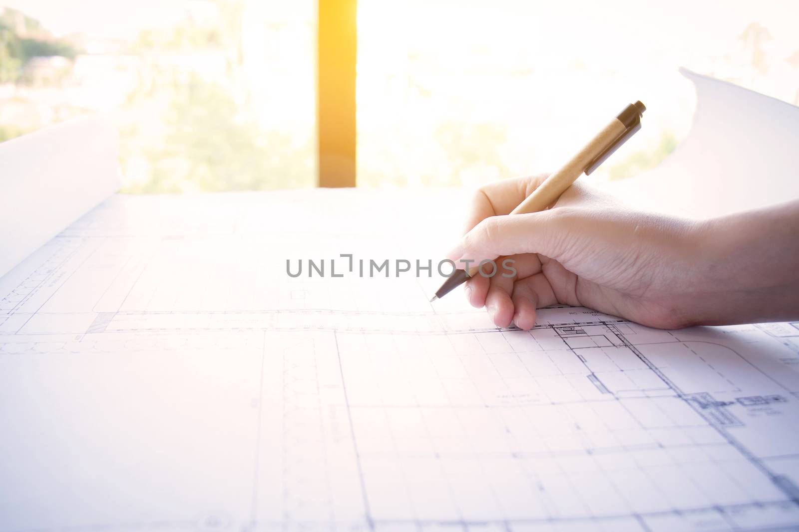 Construction , designer and renovate concept. : Architect working on blueprint, architects workplace. Architectural drawning pencil working with new startup project, side view with light effect. by asiandelight