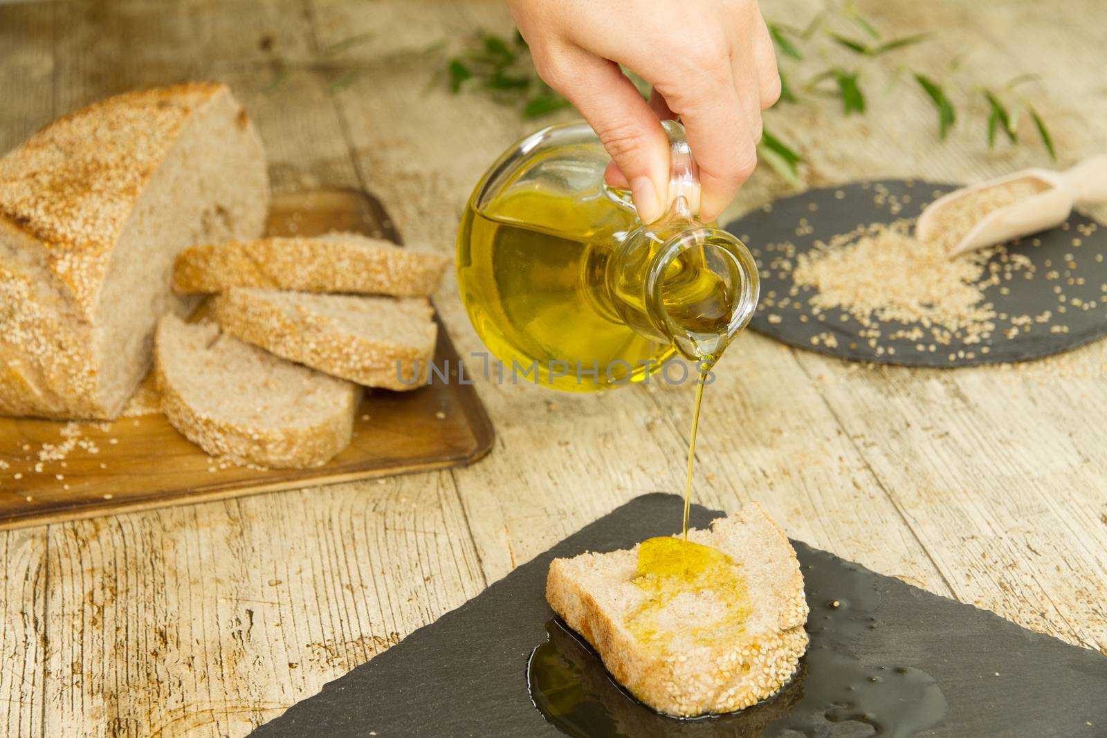 Closeup of woman hands pouring extra virgin olive oil from an am by robbyfontanesi