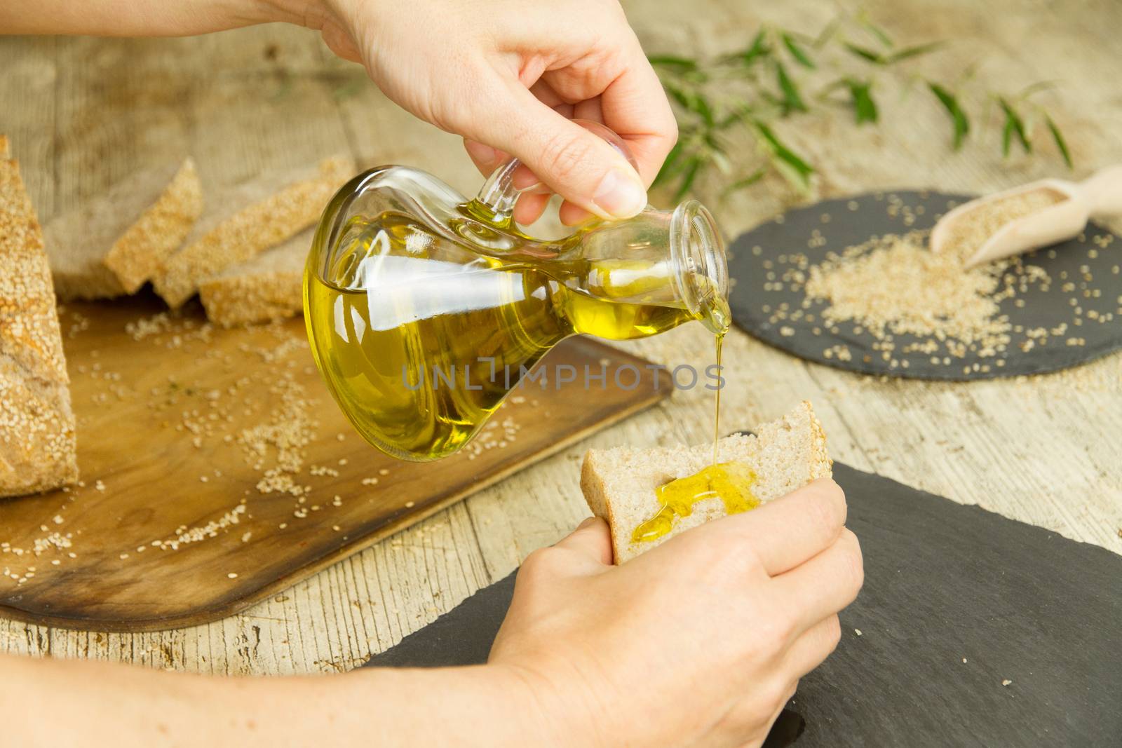 Closeup of woman hands pouring extra virgin olive oil from an am by robbyfontanesi