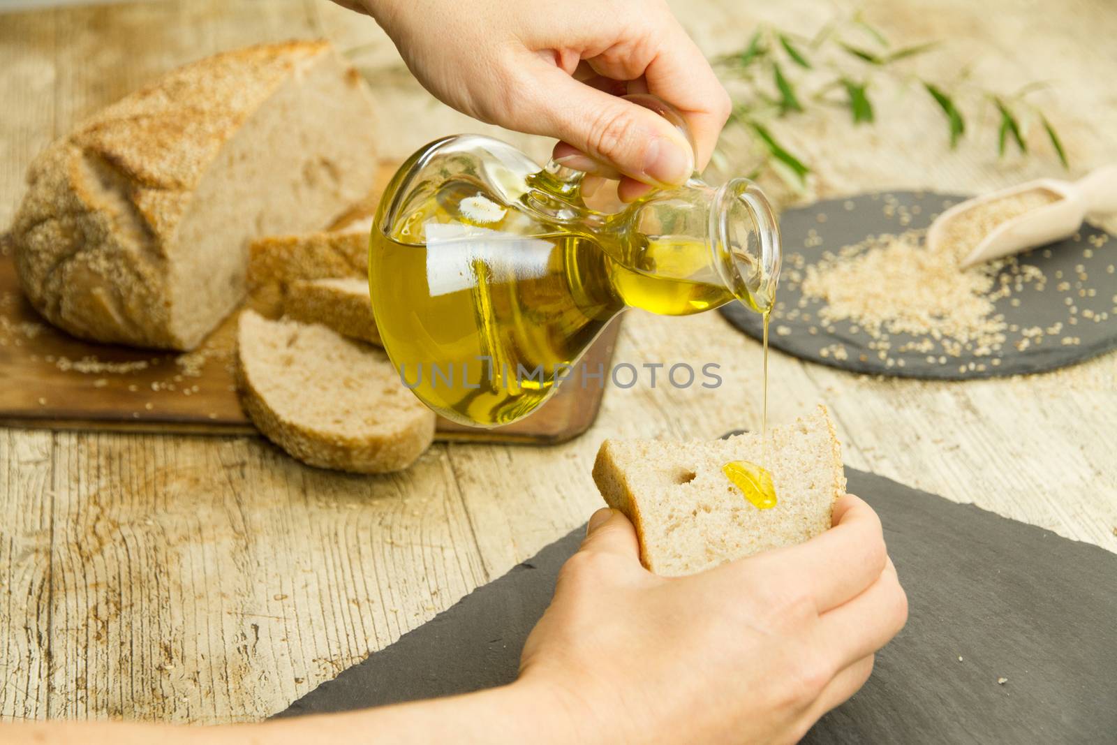 Closeup of woman hands pouring extra virgin olive oil from an am by robbyfontanesi