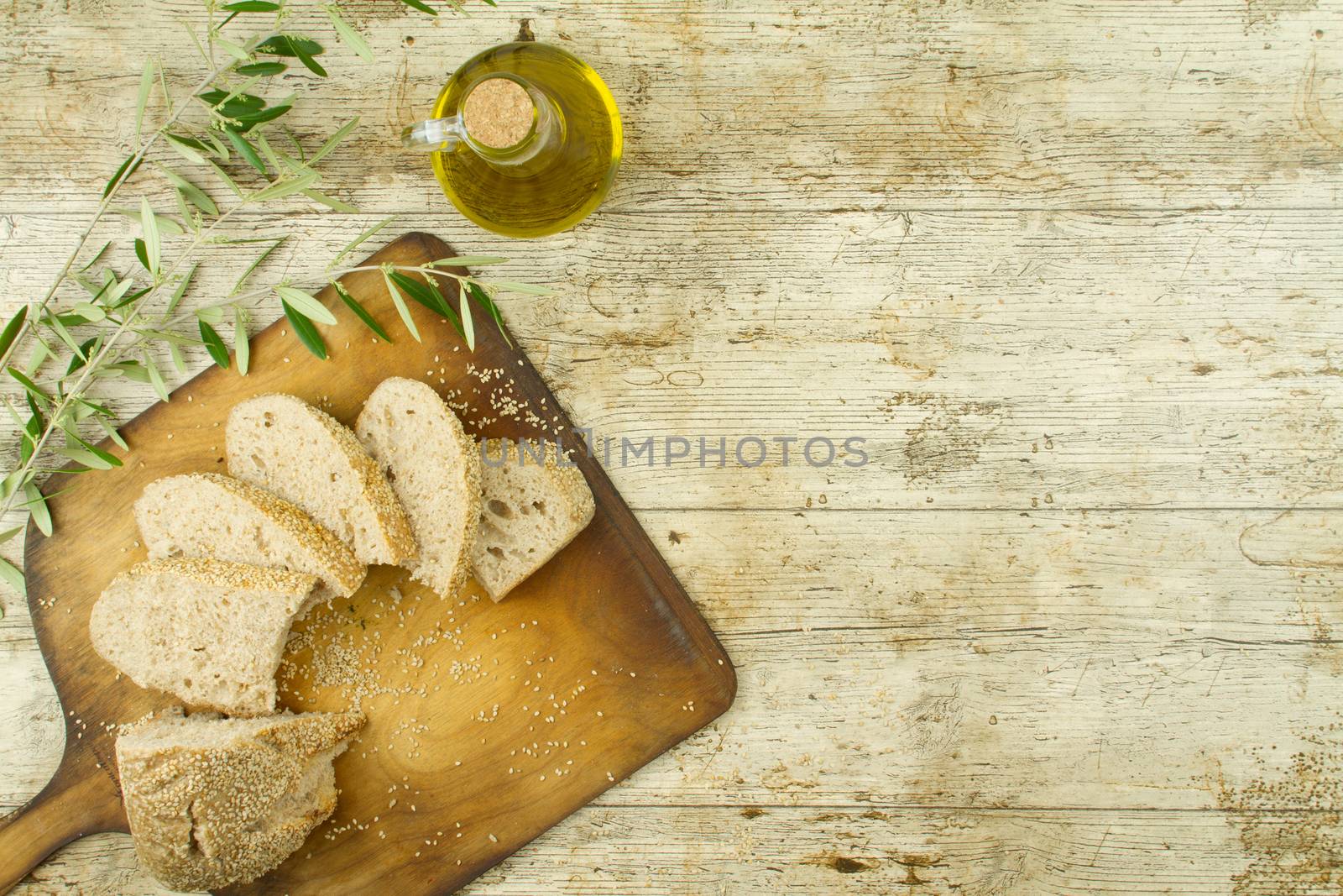 Close-up of a sliced loaf of homemade bread with sesame seeds, ampoule of ext