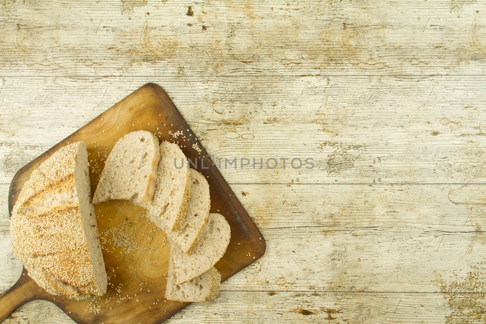 Close-up of a sliced loaf of homemade bread with sesame seeds on
