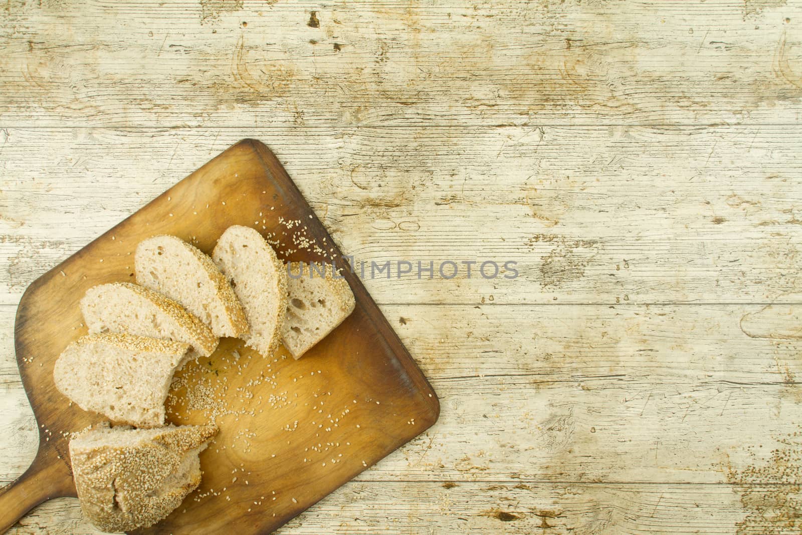 Close-up of a sliced loaf of homemade bread with sesame seeds, a