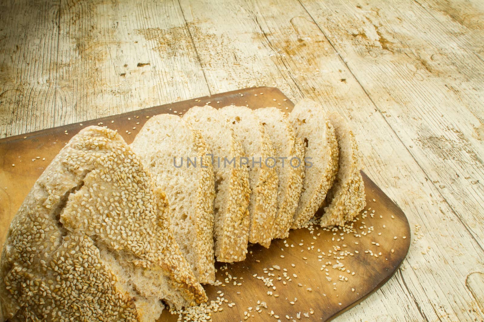 Close-up of a sliced loaf of homemade bread with sesame seeds o by robbyfontanesi