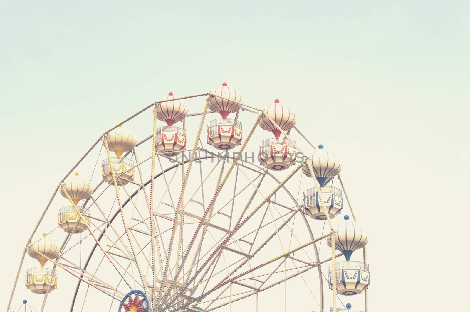 Ferris wheel on sky background with sunlight retro effect image