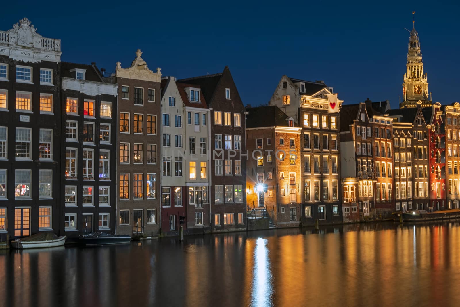 Amsterdam houses along the Damrak in the Netherlands at night