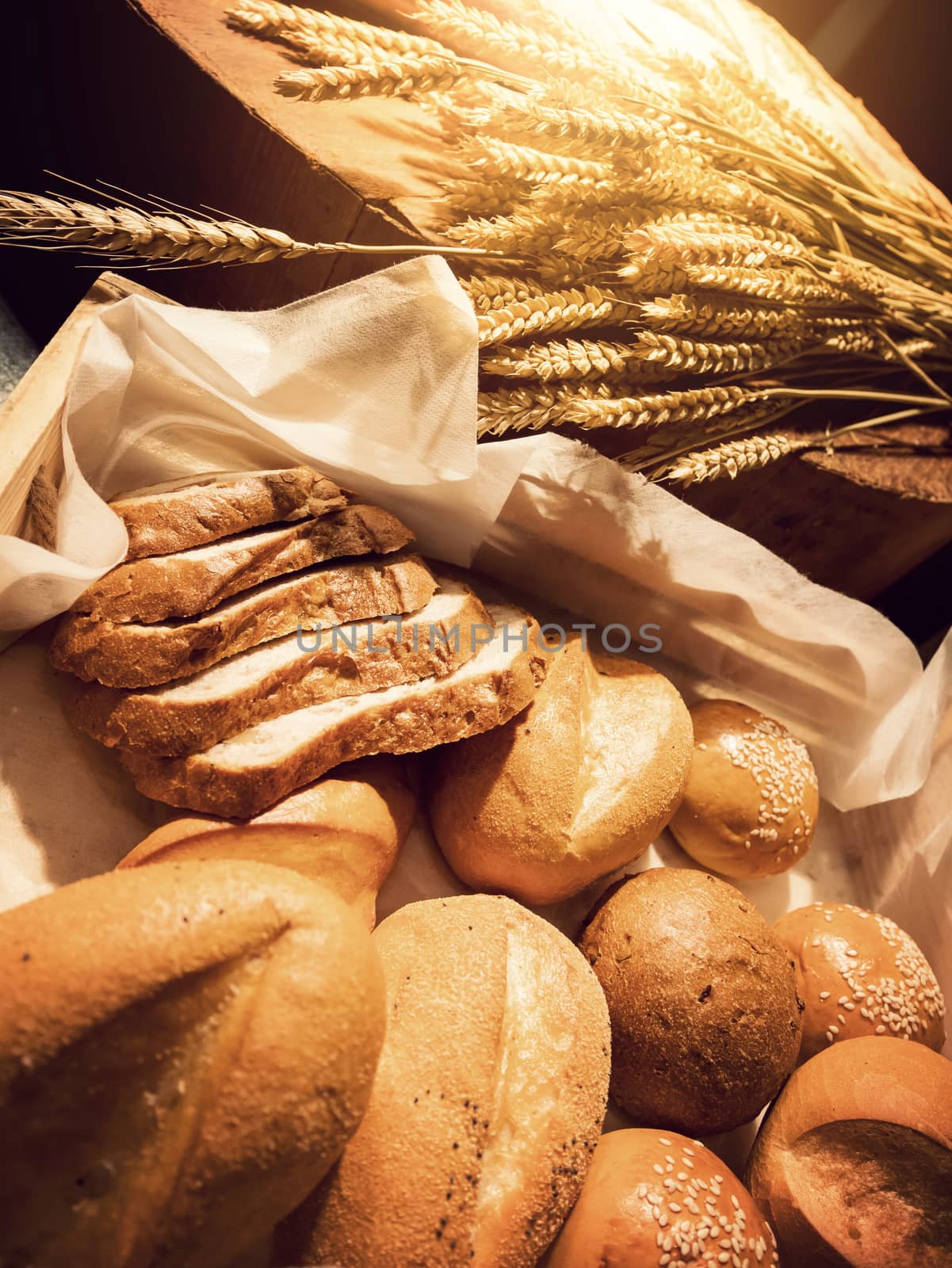 Homemade bakery concept : fresh bread and wheat on the wooden table with warm light by asiandelight