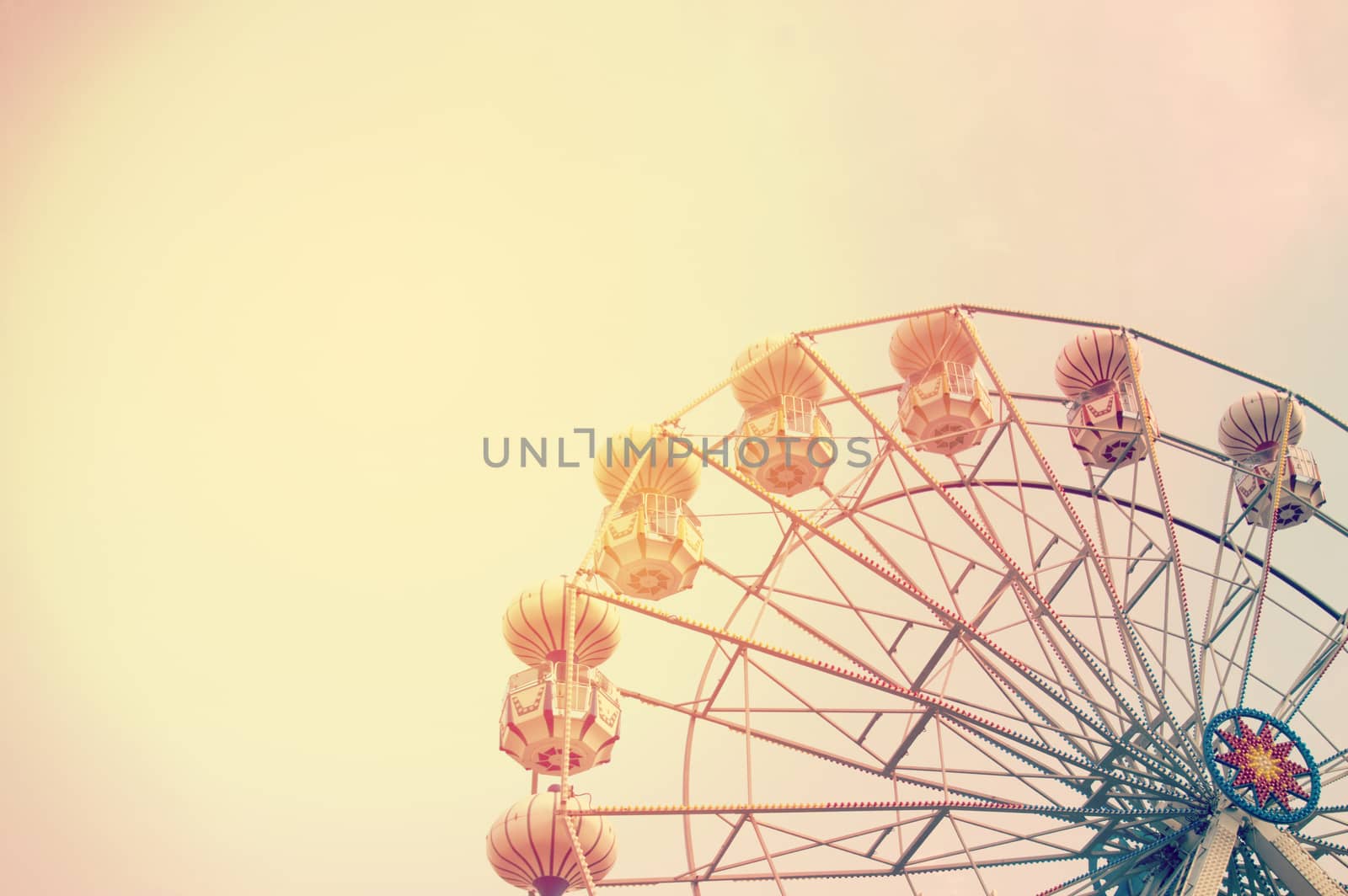 Ferris wheel on sky background with sunlight retro effect image