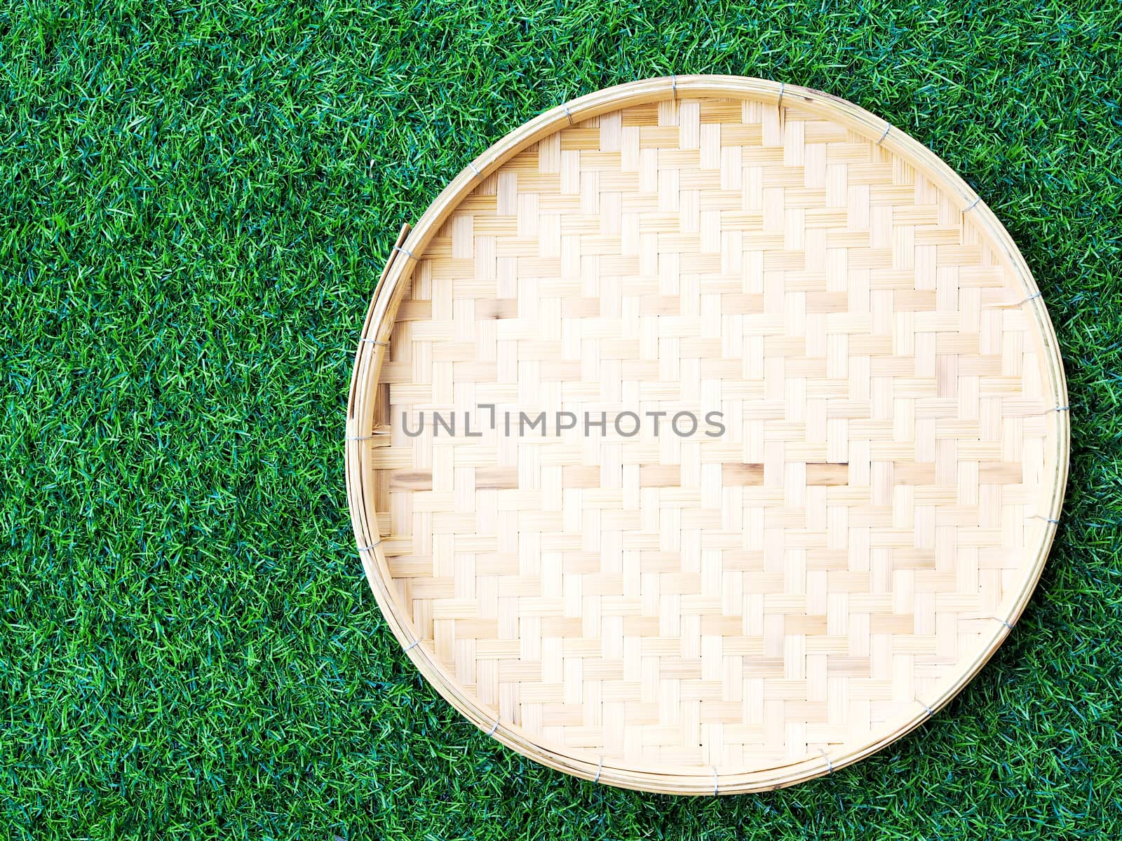 Above of bamboo weave basket on green grass, background by kittima05