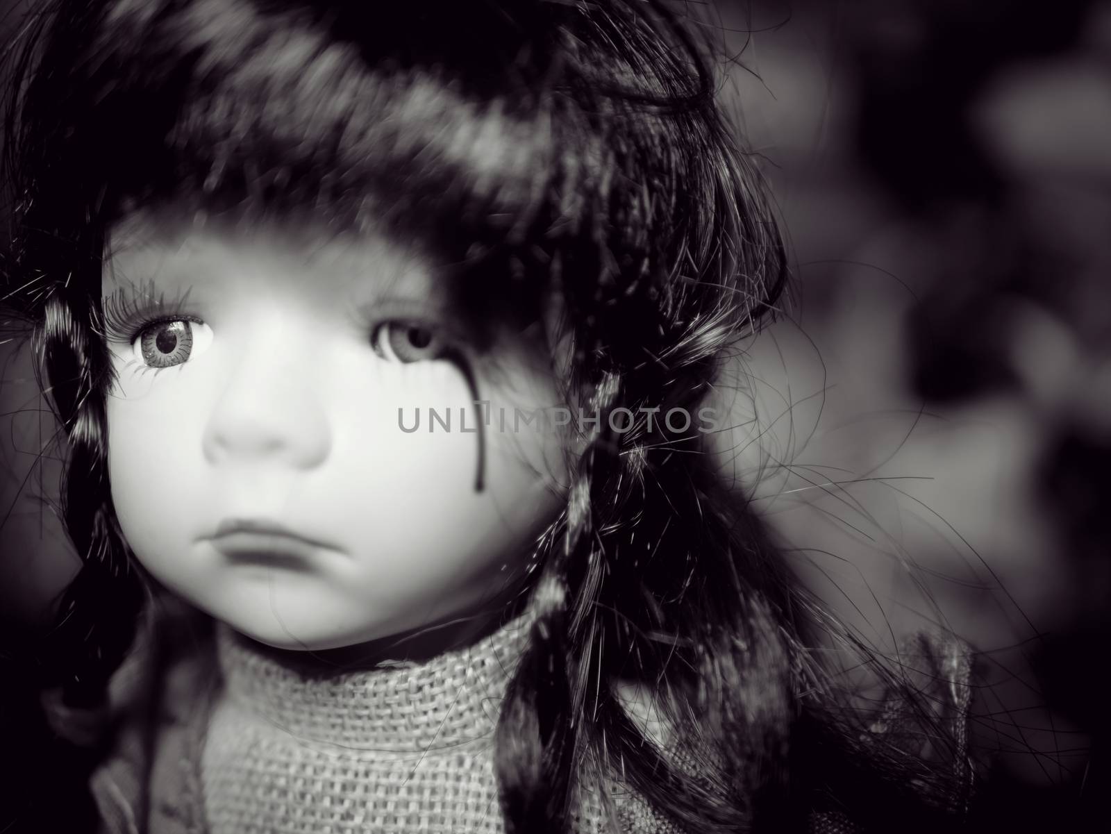 Anti children violence family problem campaign concept : cute girl child doll crying with blood of tear from family social violence. black and white color by asiandelight