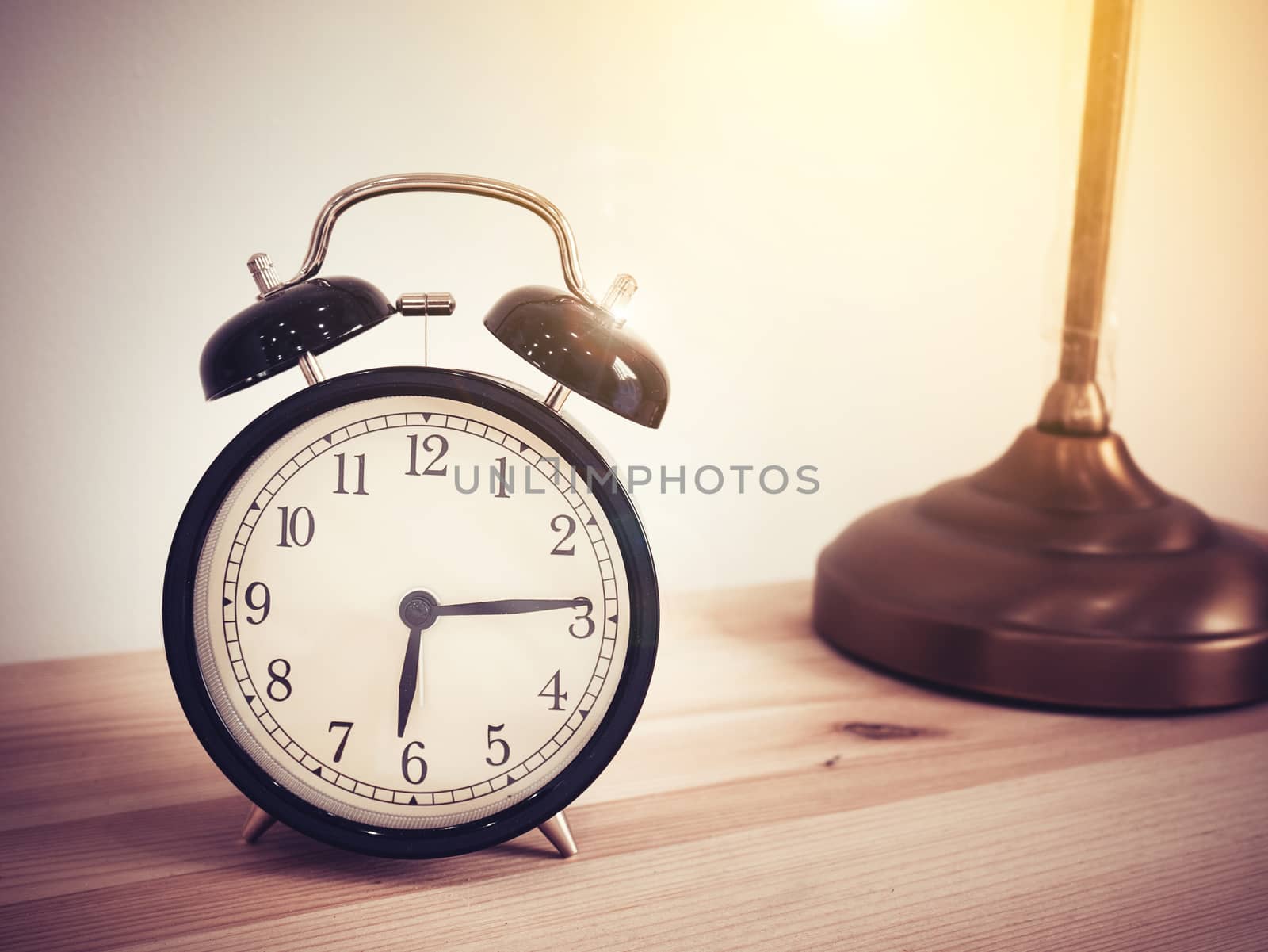 Closeup retro alarm clock on wooden table with copy space, retro style by asiandelight