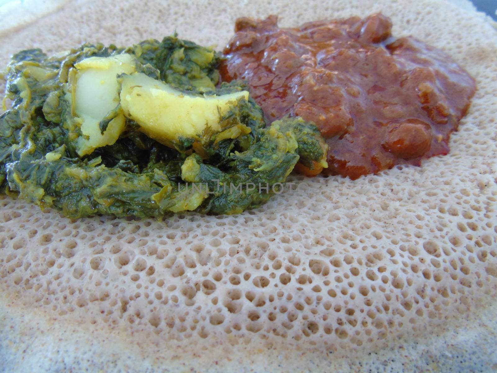 Asmara, Eritrea - 08/05/2020: Ethiopian and Eritrean food, assortment of main dishes. Injera is a sourdough flatbread made from teff flour. It is the national dish of Ethiopia, Eritrea.