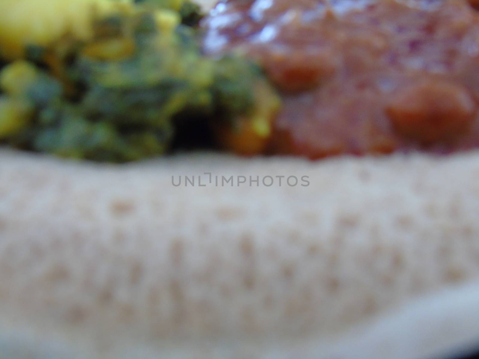 Asmara, Eritrea - 08/05/2020: Ethiopian and Eritrean food, assortment of main dishes. Injera is a sourdough flatbread made from teff flour. It is the national dish of Ethiopia, Eritrea.