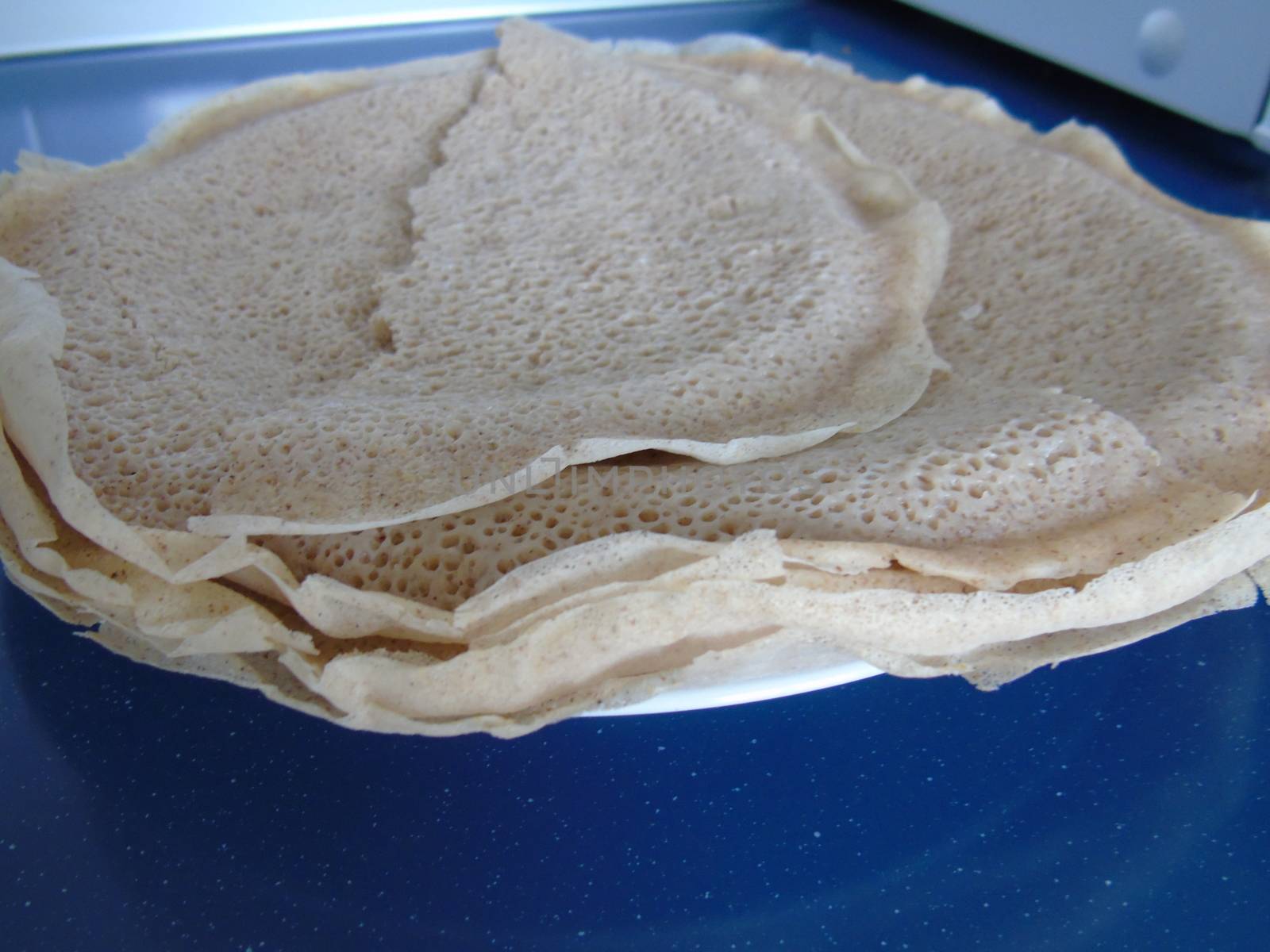 Asmara, Eritrea - 08/05/2020: Ethiopian and Eritrean food, assortment of main dishes. Injera is a sourdough flatbread made from teff flour. It is the national dish of Ethiopia, Eritrea.