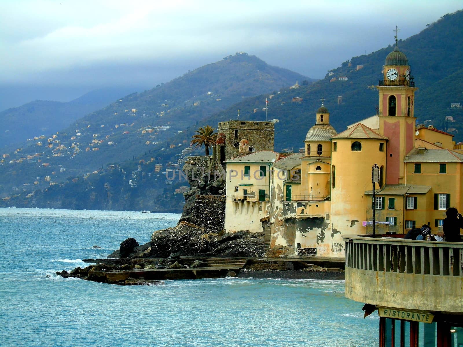 Liguria, Italy - 06/15/2020: Travelling around the ligurian seaside. Panoramic view to the seaside and the old villages. An amazing caption of the medieval coloured houses with grey sky in the background.