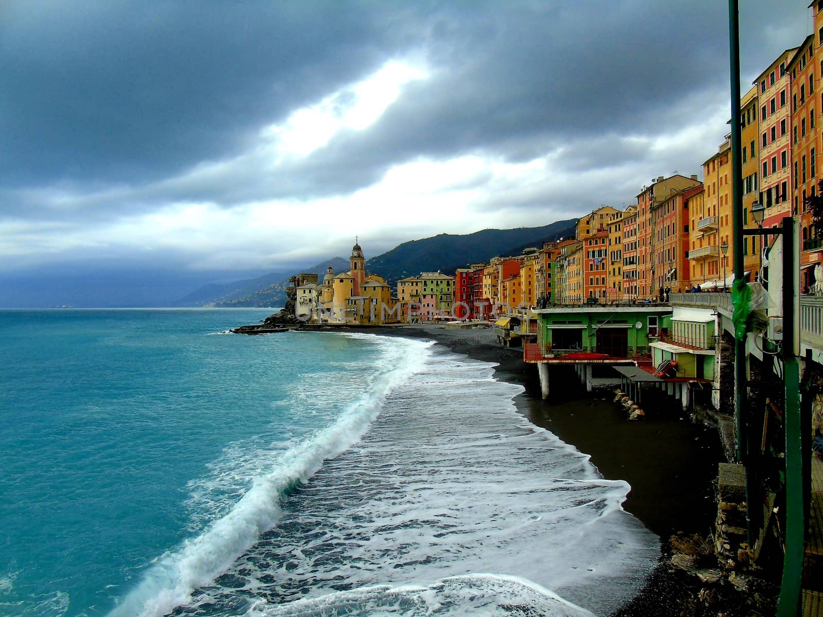 Liguria, Italy - 06/15/2020: Travelling around the ligurian seaside. Panoramic view to the seaside and the old villages. An amazing caption of the medieval coloured houses with grey sky in the background.