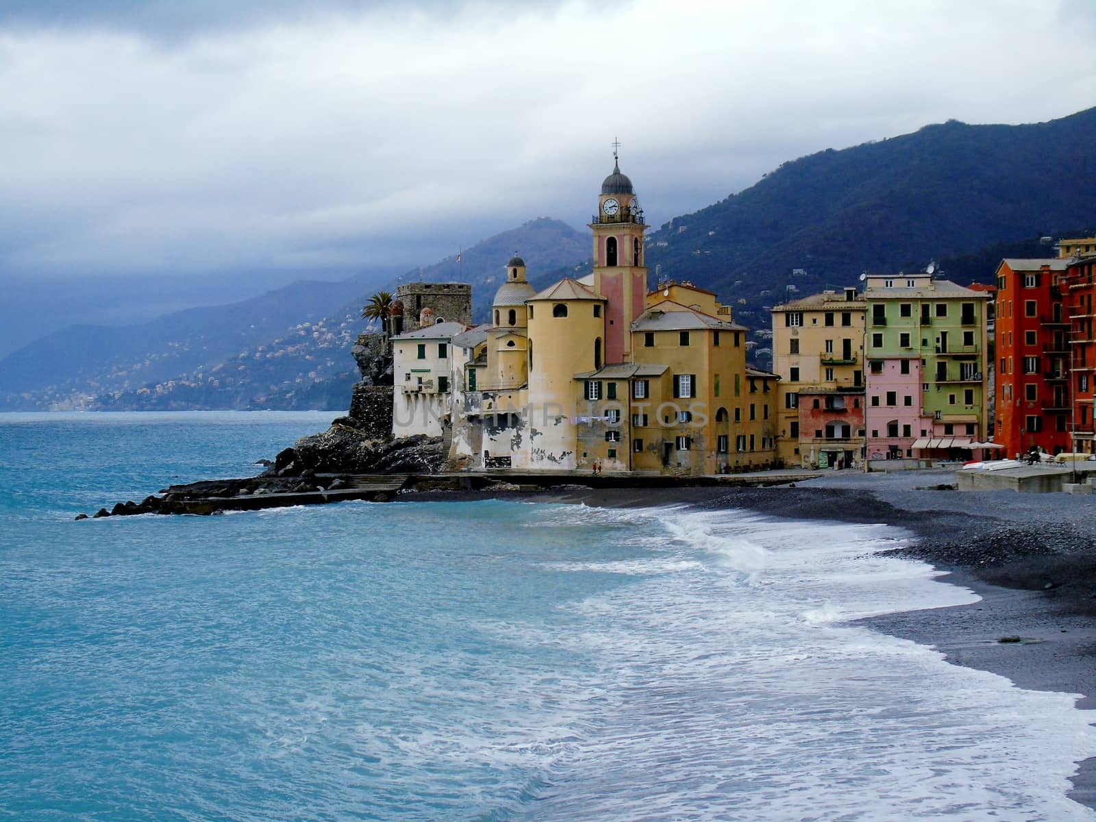 Liguria, Italy - 06/15/2020: Travelling around the ligurian seaside. Panoramic view to the seaside and the old villages. An amazing caption of the medieval coloured houses with grey sky in the background.