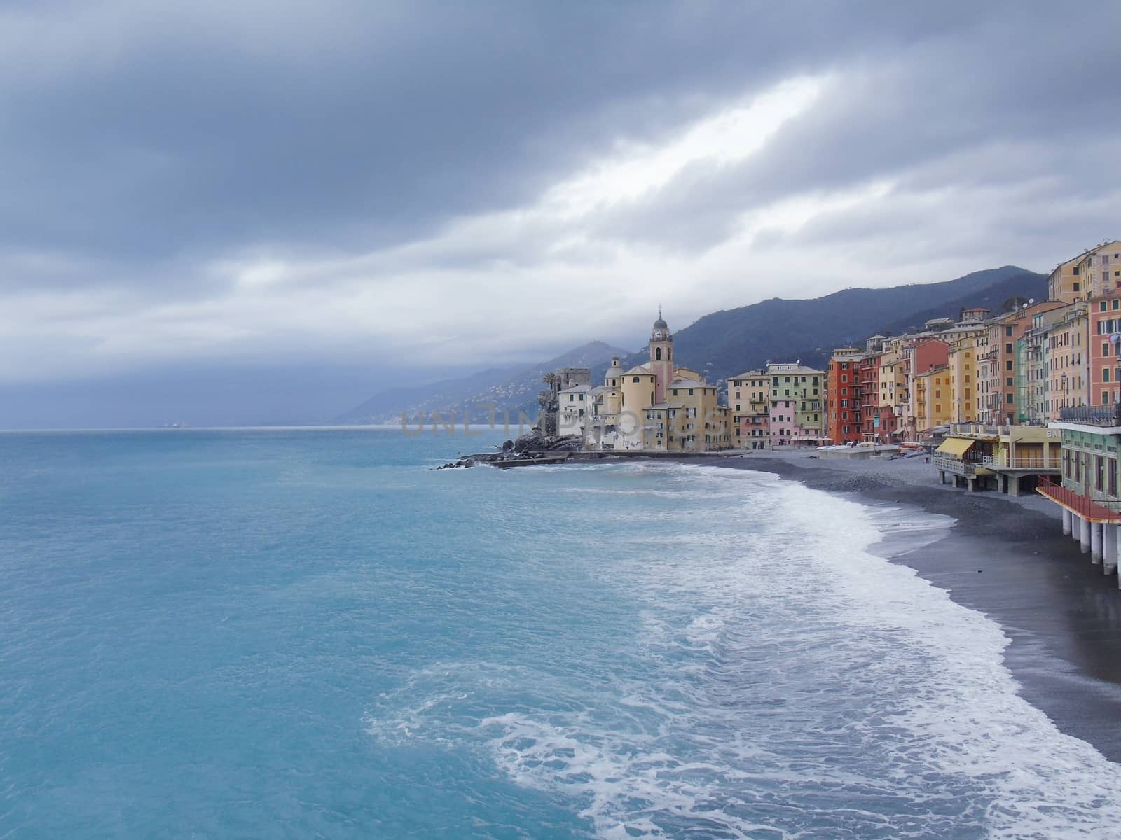 Liguria, Italy - 06/15/2020: Travelling around the ligurian seaside. Panoramic view to the seaside and the old villages. An amazing caption of the medieval coloured houses with grey sky in the background.