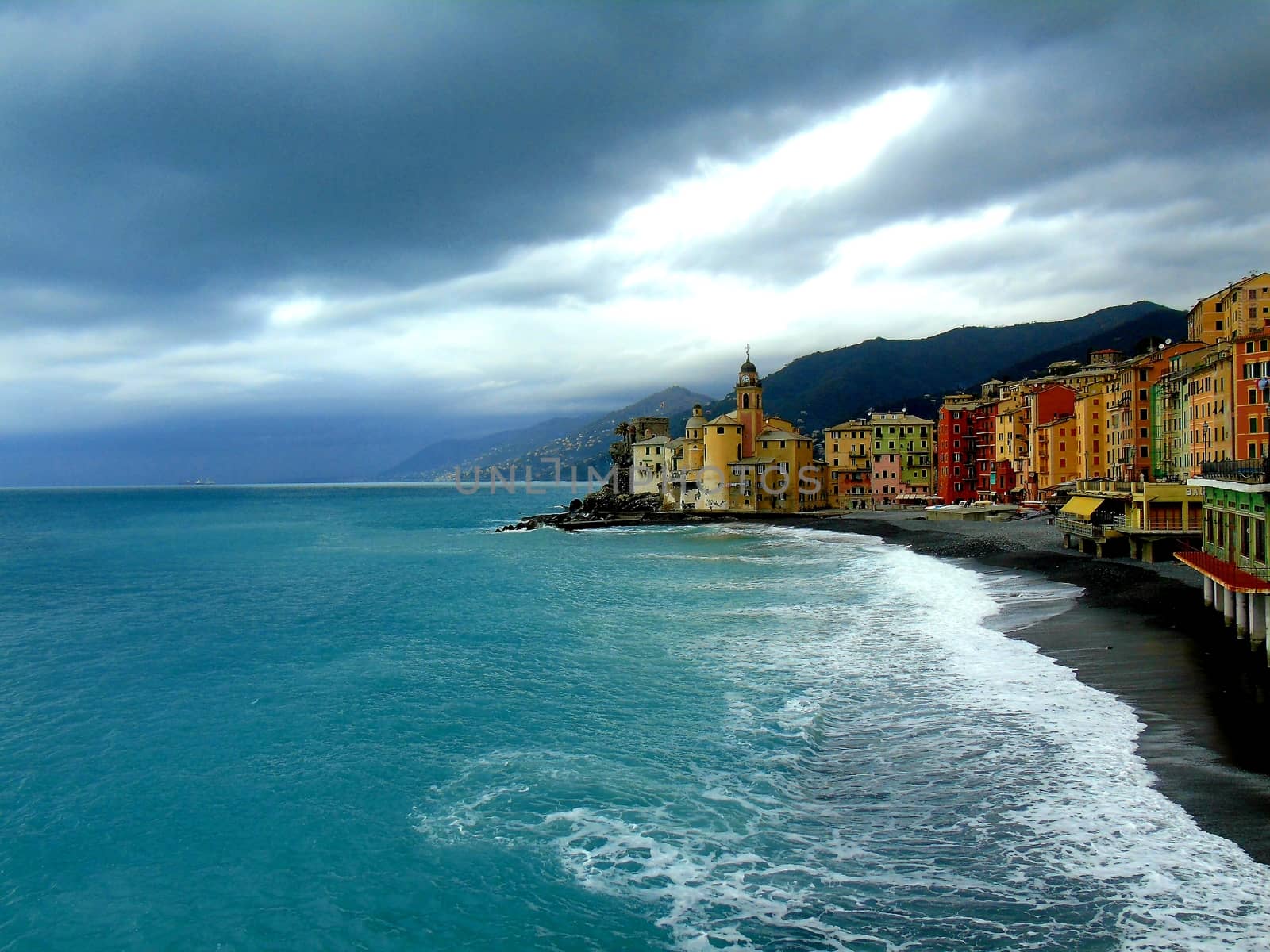 Liguria, Italy - 06/15/2020: Travelling around the ligurian seaside. Panoramic view to the seaside and the old villages. An amazing caption of the medieval coloured houses with grey sky in the background.