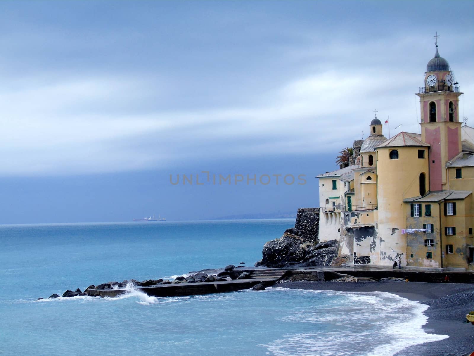 Liguria, Italy - 06/15/2020: Travelling around the ligurian seaside. Panoramic view to the seaside and the old villages. An amazing caption of the medieval coloured houses with grey sky in the background.