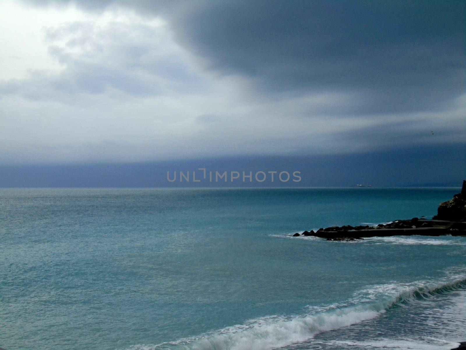 Liguria, Italy - 06/15/2020: Travelling around the ligurian seaside. Panoramic view to the seaside and the old villages. An amazing caption of the medieval coloured houses with grey sky in the background.