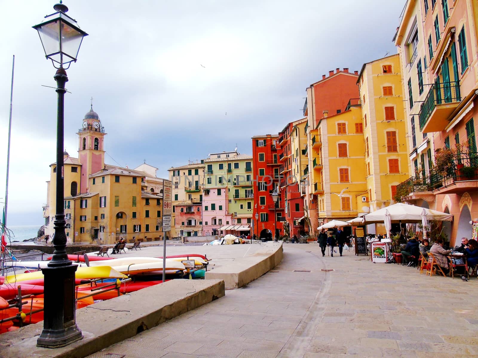 Liguria, Italy - 06/15/2020: Travelling around the ligurian seaside. Panoramic view to the seaside and the old villages. An amazing caption of the medieval coloured houses with grey sky in the background.