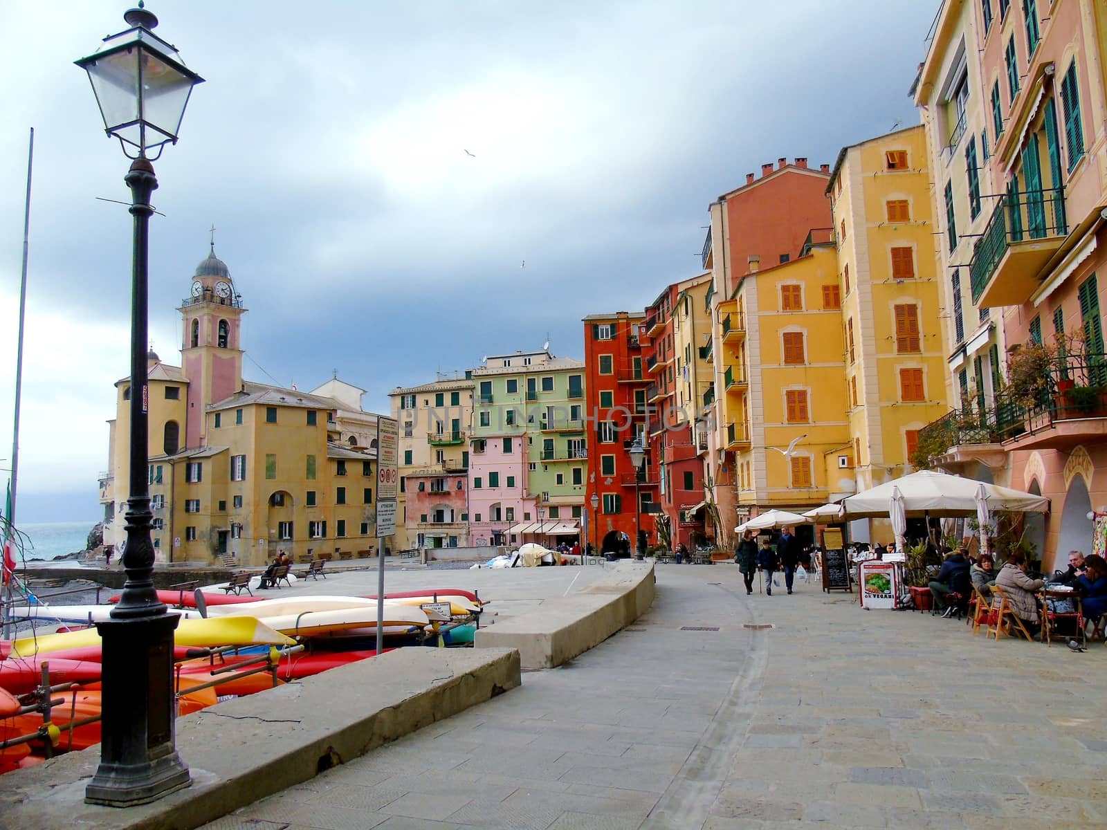 Liguria, Italy - 06/15/2020: Travelling around the ligurian seaside. Panoramic view to the seaside and the old villages. An amazing caption of the medieval coloured houses with grey sky in the background.