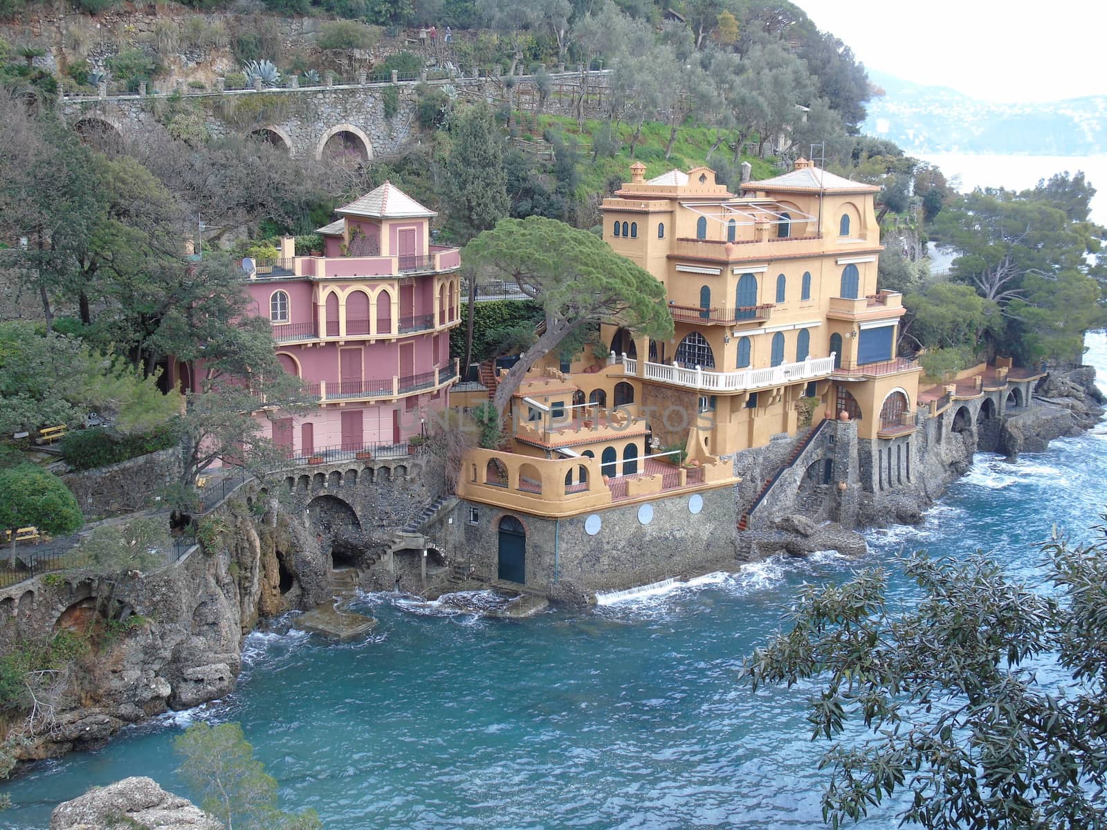 Liguria, Italy - 06/15/2020: Travelling around the ligurian seaside. Panoramic view to the seaside and the old villages. An amazing caption of the medieval coloured houses with grey sky in the background.