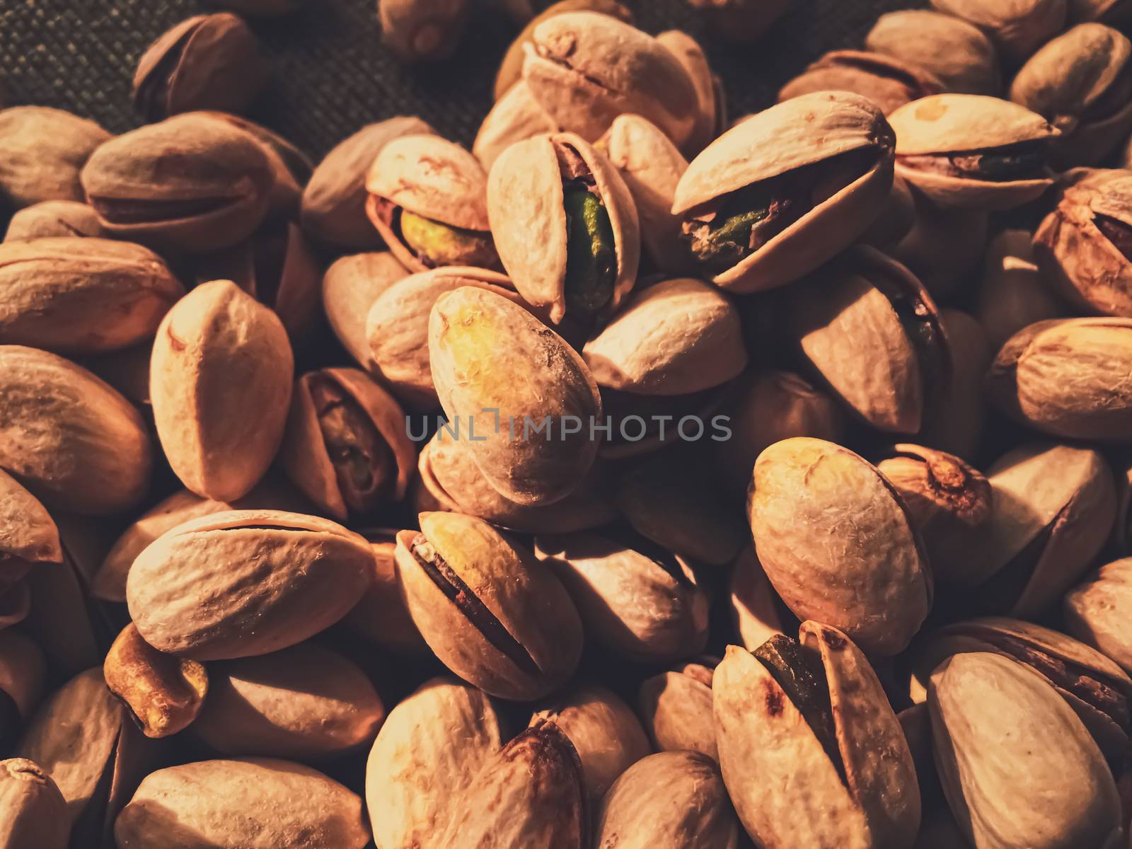 Pistachio nuts on rustic linen background, food and nutrition