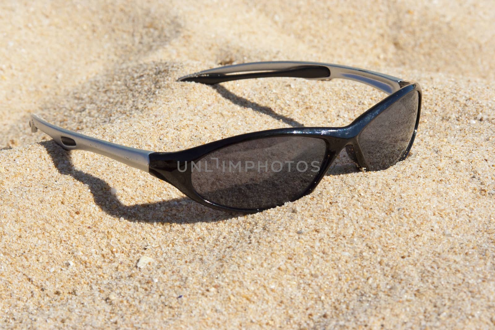Sunglasses on a sandy beach in summer
