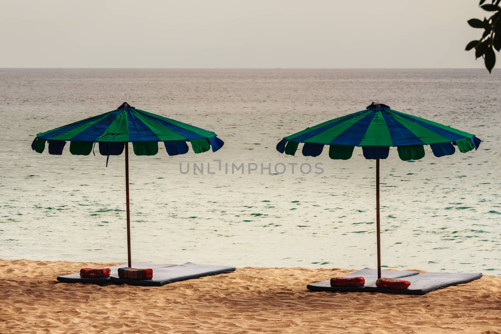 Beautiful sandy beach with umbrella, mattress and pillow by kwhisky
