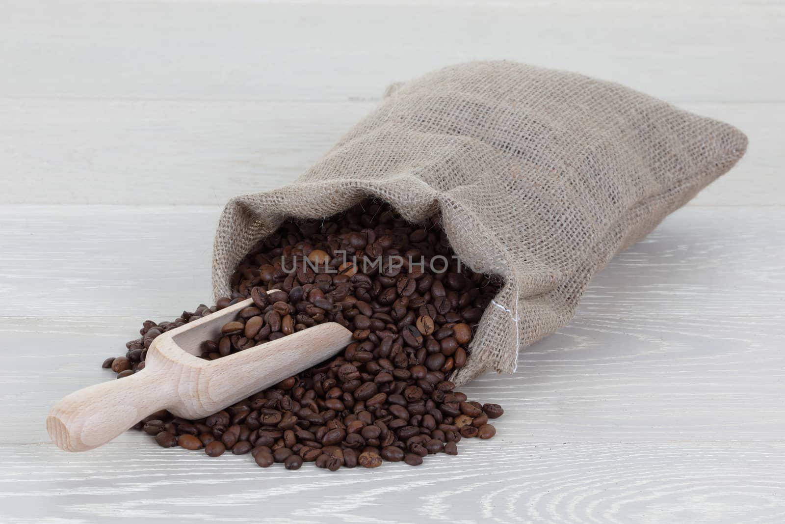 Coffee bean scoop and bag on wood surface