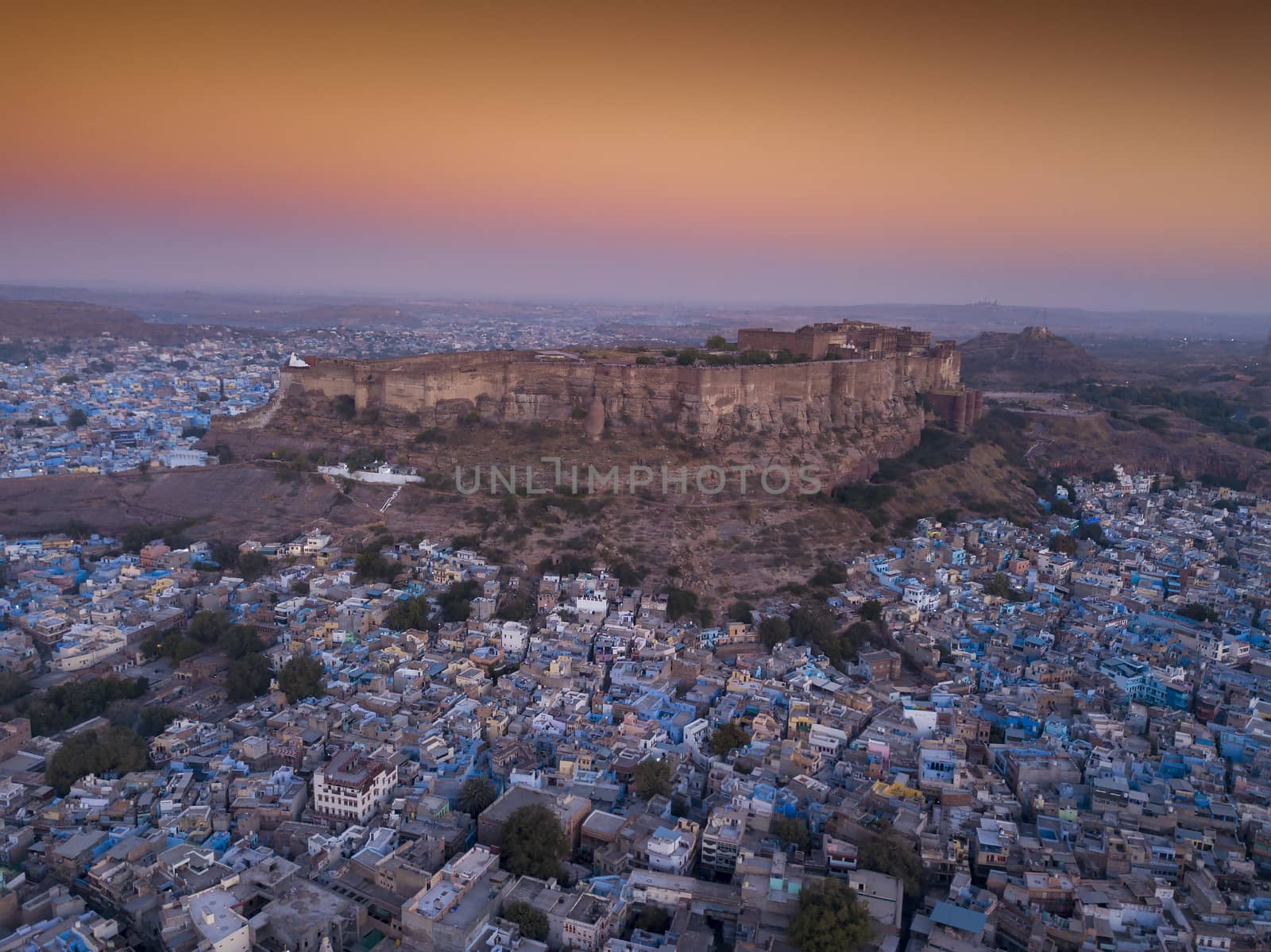 Aerial view of Mehrangarh Fort at sunset sits above the 'Blue City' Jodhpur, Rajasthan State India.