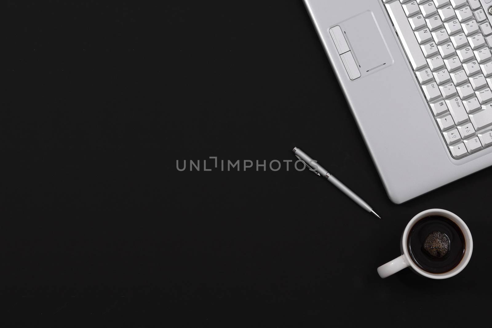 A black minimalist home office desk pen coffee laptop top view with copy space