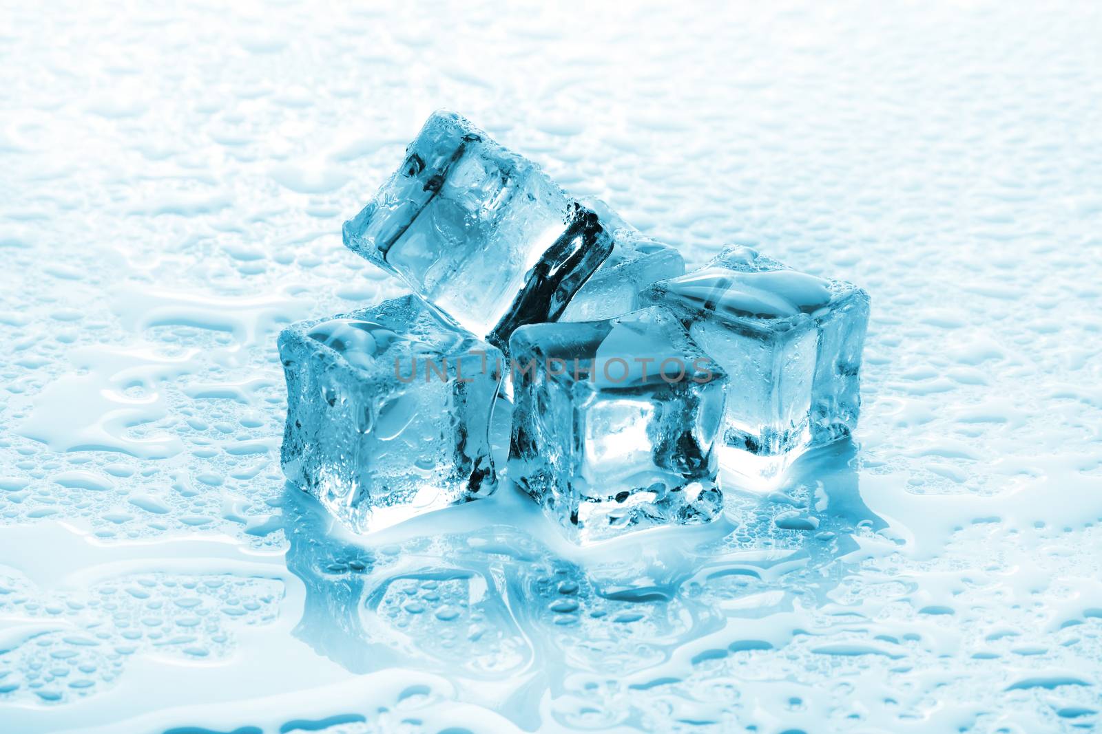 A pile of six ice cubes on a wet background