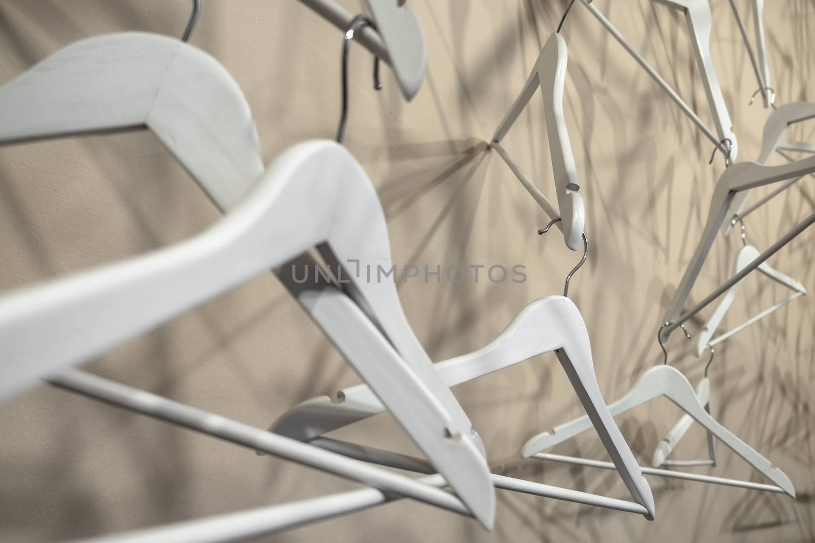 Empty wooden clothes hangers casting deep shadows. Real coat hanger wood pattern. Abstract fashion concept.