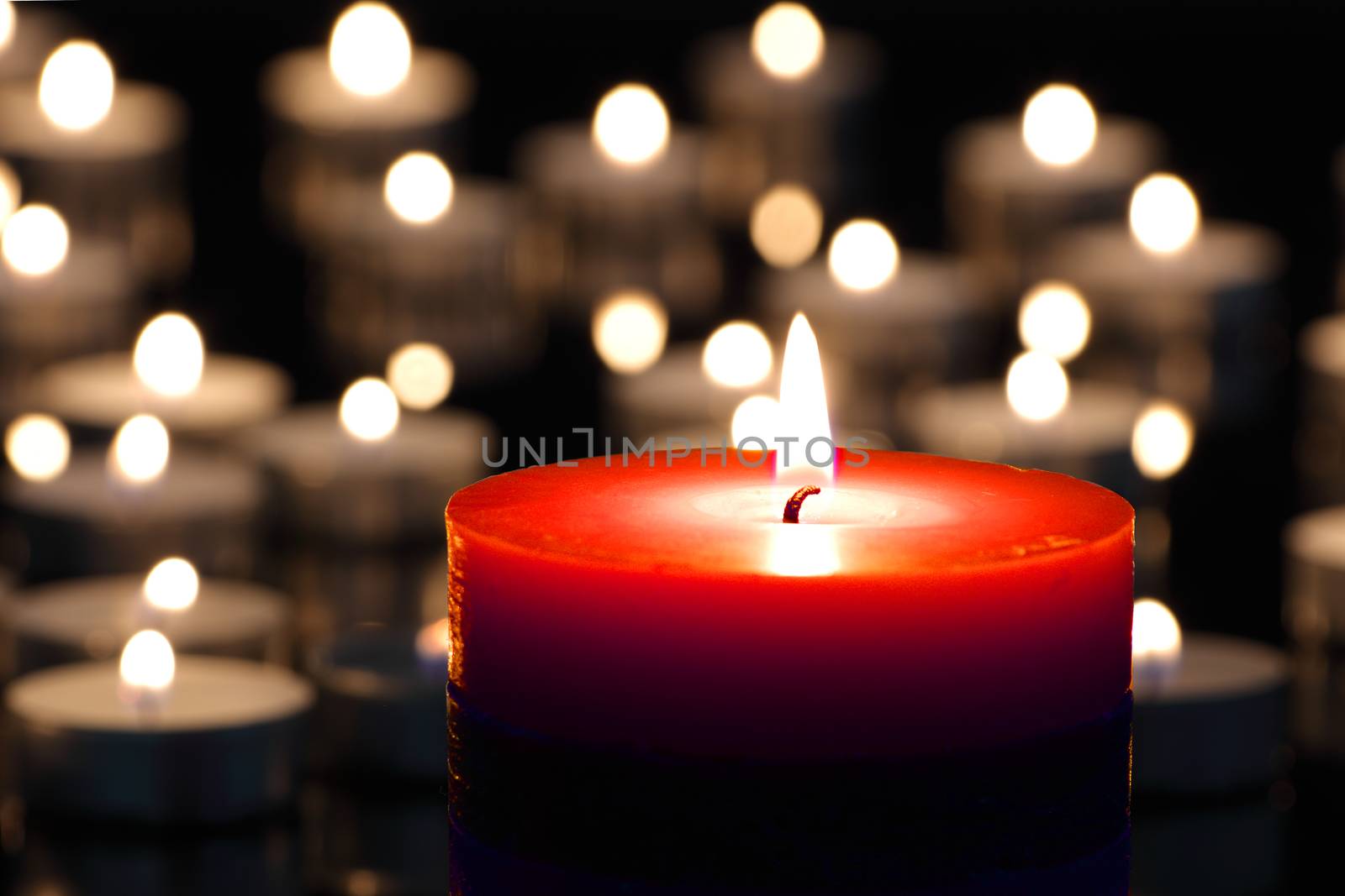 A red candle on christmas night signifying hope. Gold. Background. Selective focus.