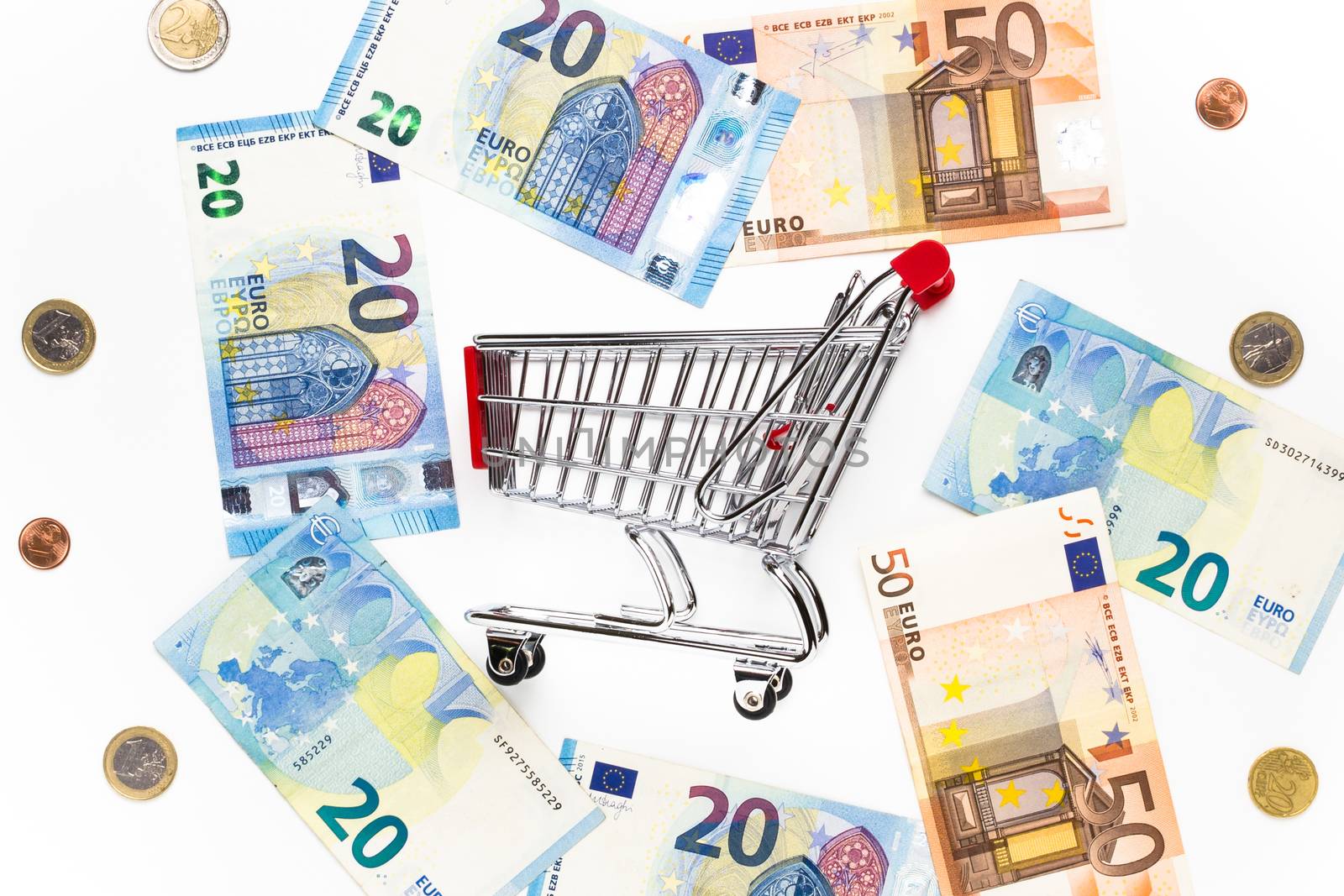 Empty shopping cart with around various banknotes and metal mone by germanopoli