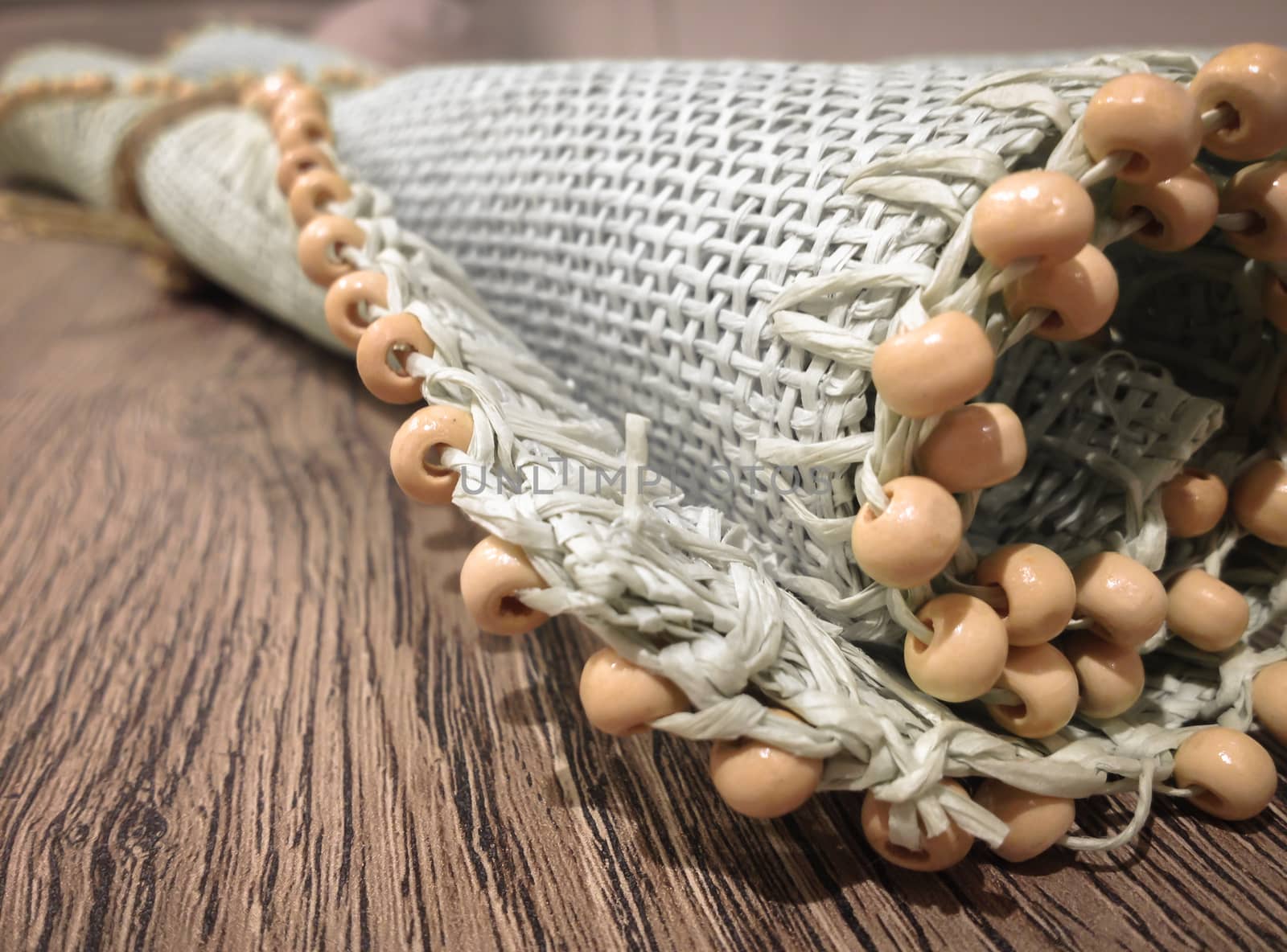 Small roller wicker mat on vintage table. Furnishing accessory for home. Close-up.