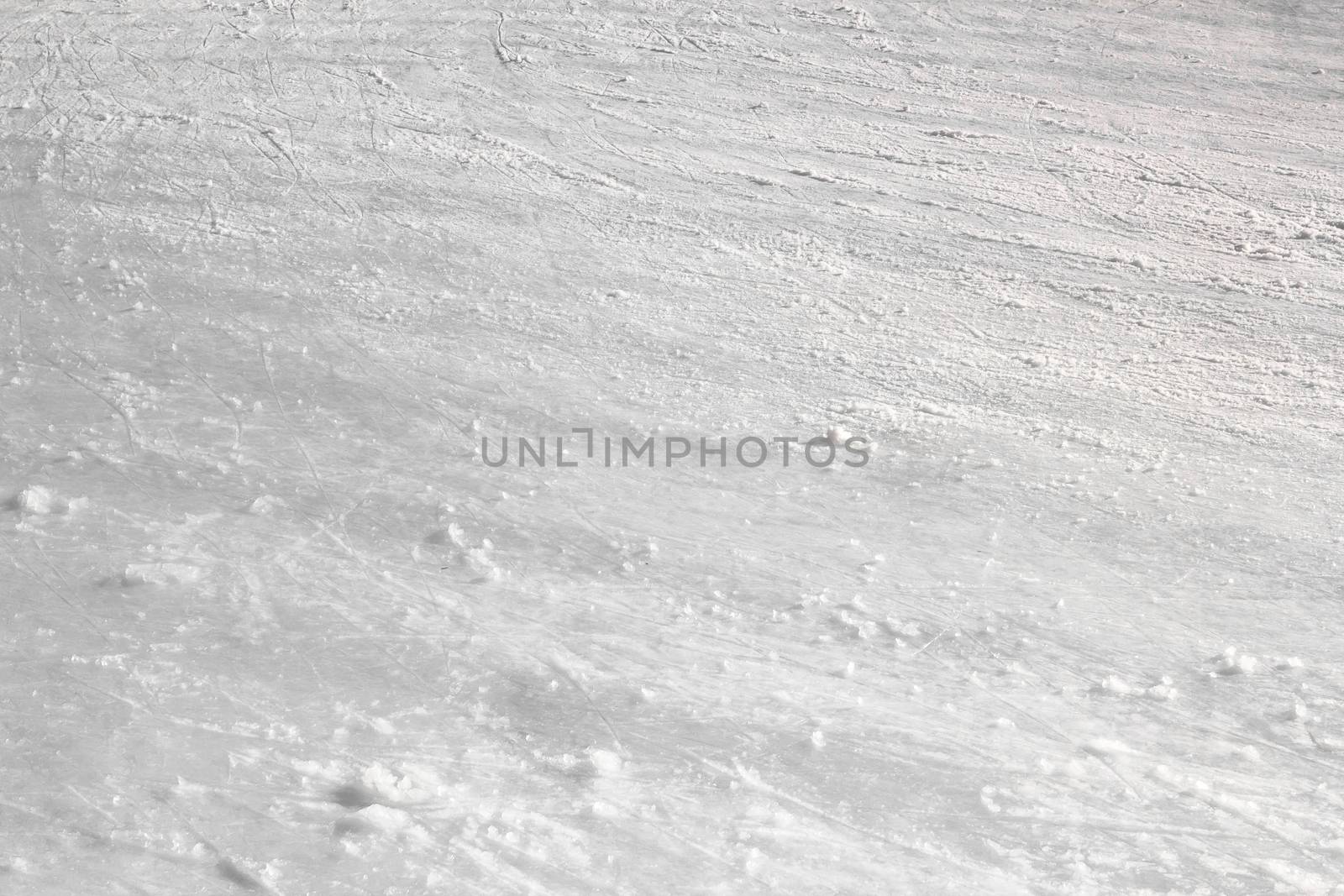 Close up of white ice surface with a traces left by the skates. Ideal for texture and backgrounds.