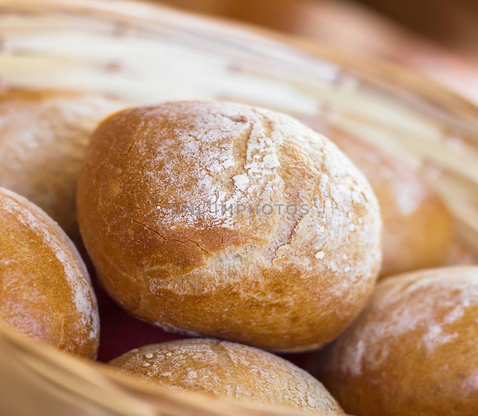 Bread and buns inside basket. Fresh bakery products on table. Shallow dof.