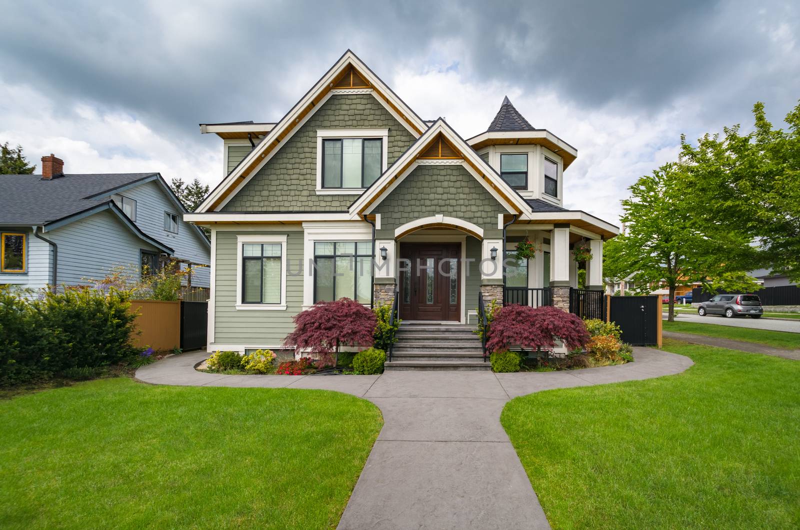 Residential family house with concrete pathway over front yard. Family house with a car parked on side