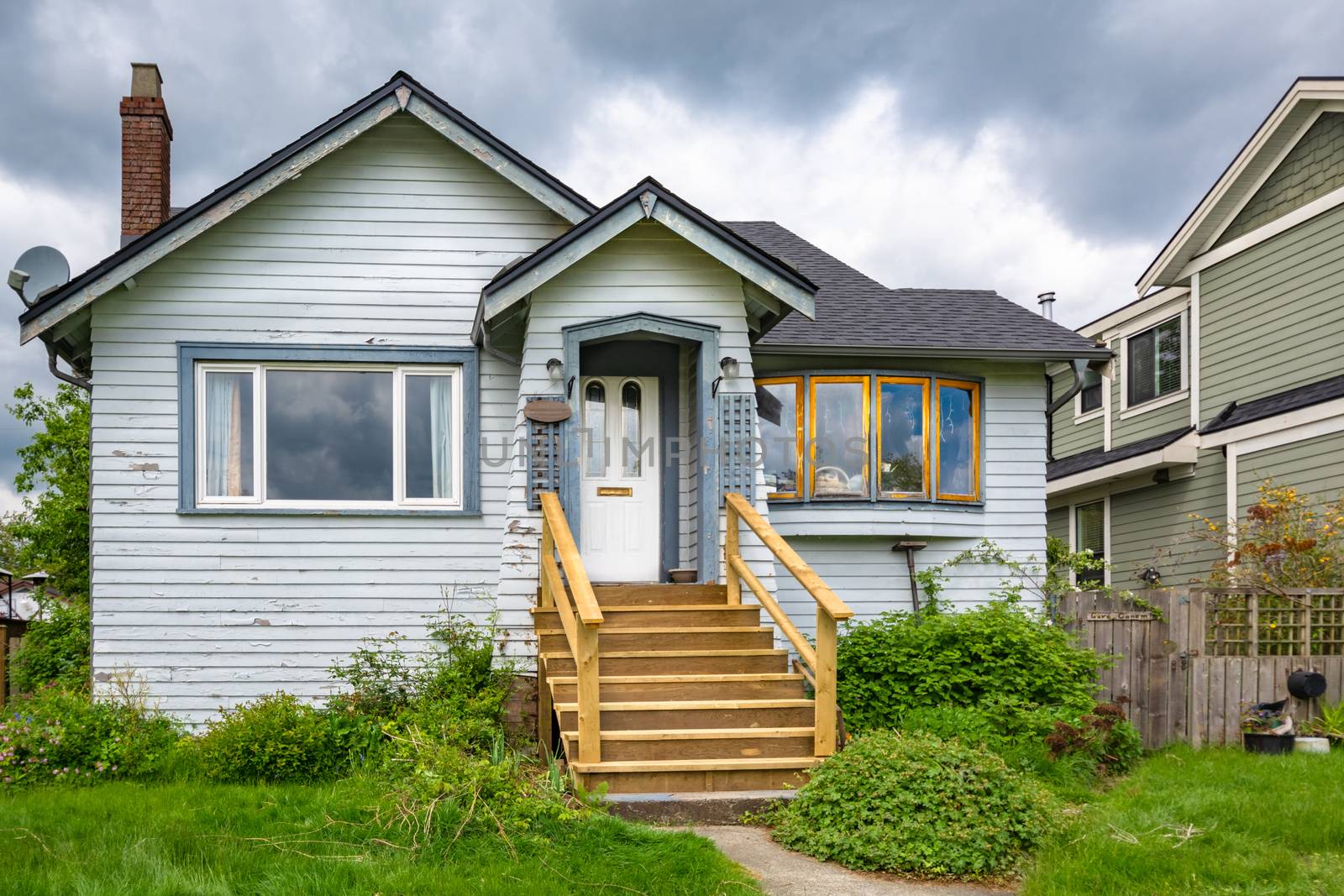 Old residential house with neglected lawn on the front yard