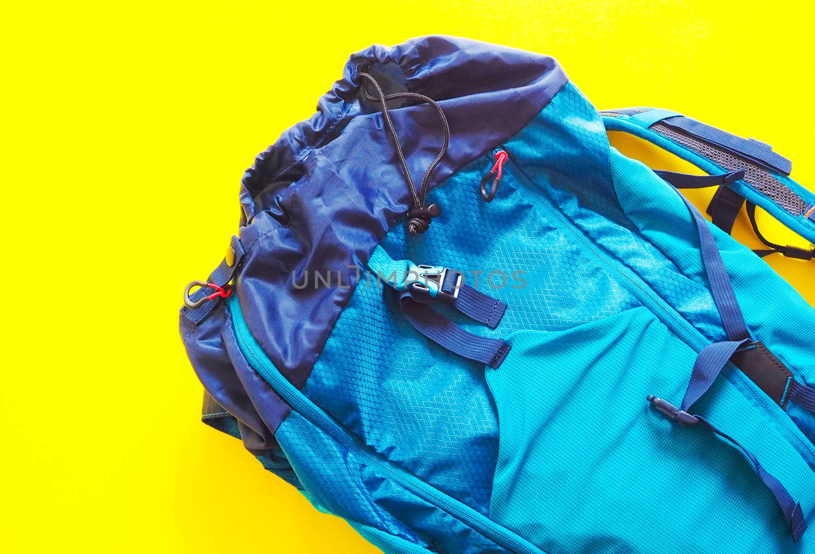 Blue travel backpack. Isolated on yellow background.