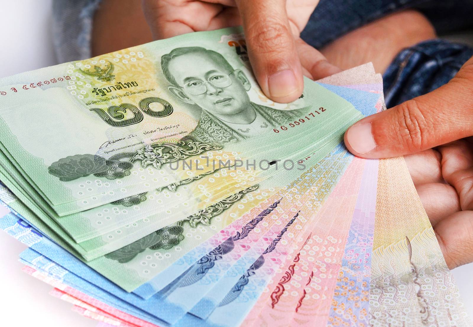 Hand holding Thai baht banknotes. money of thailand. Income by kittima05