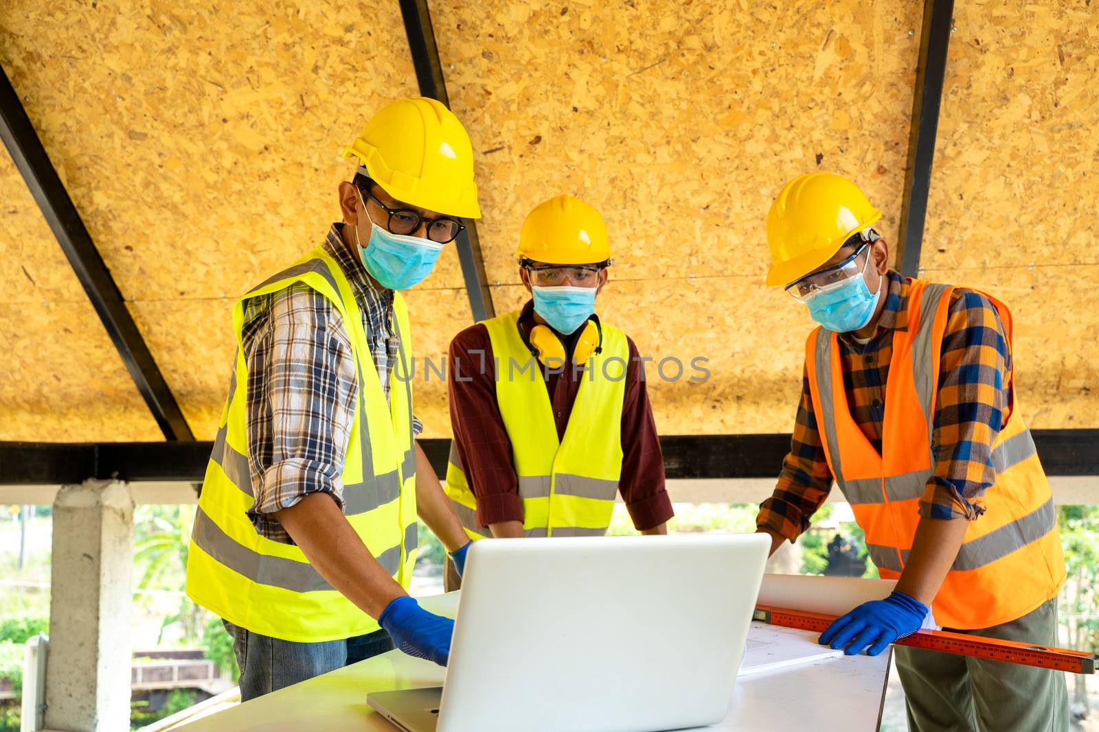 Engineer wearing protective mask working and meeting at construction site.