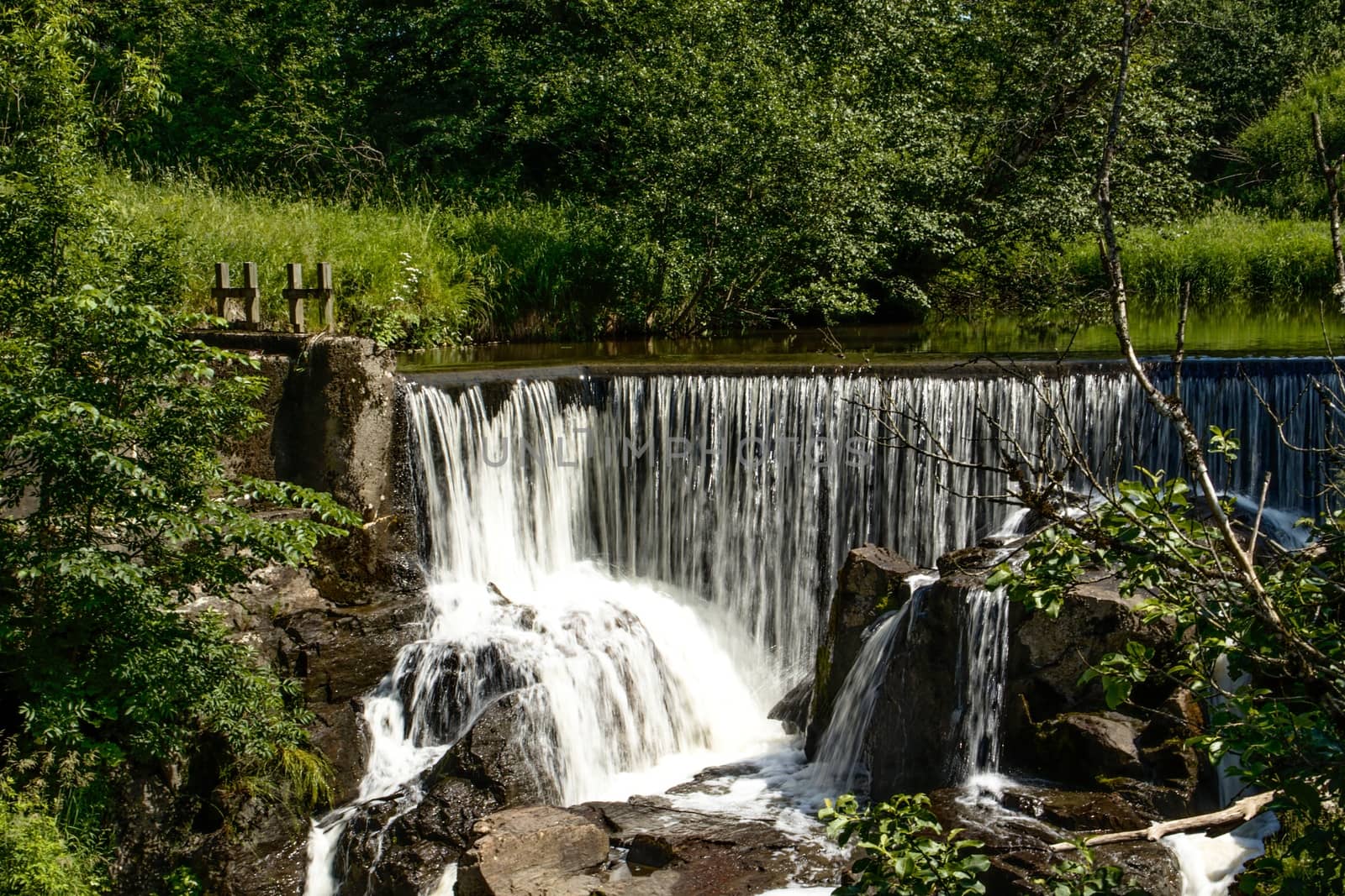 A small waterfall off an old powerplant dam, in the forest