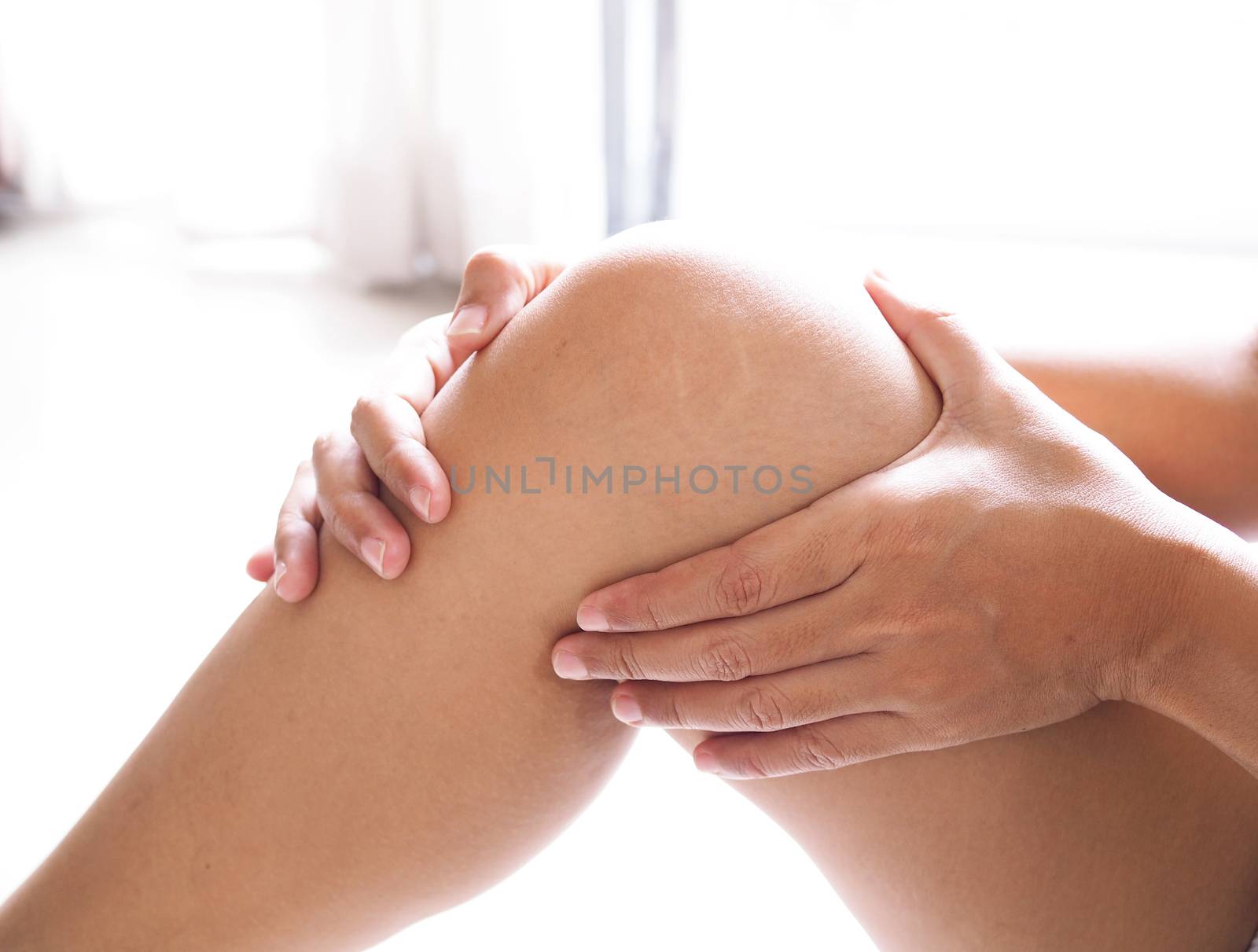 Asian woman suffering from Leg and knee pain, Have symptoms muscle injury or chronic tendon inflammation.